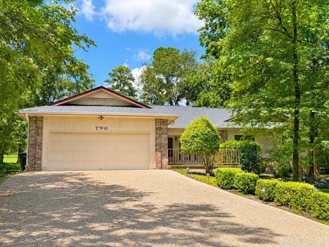 Nestled on Hole #8 (Par 5) of Ponce de Leon golf course in the highly sought-after Hot Springs Village, 2 Serenaded Trace offers peaceful fairway views, and spacious living. Features an open-concept layout with soaring ceilings, and large windows that bring the outdoors in. The heart of the home is the expansive kitchen, complete w/ a large center island, generous granite countertops, abundant custom oak cabinetry, double wall ovens, built-in microwave, cooktop, and oversized refrigerator/freezer system—perfect for entertaining or everyday living. A convenient wet bar adds extra functionality for hosting guests. The inviting living area showcases a stunning floor-to-ceiling brick fireplace w/ built-in shelving, while the dining area and multiple living spaces flow seamlessly together. Throughout the home, neutral finishes, durable flooring, and fresh, bright interiors create a move-in-ready feel. Additional highlights include a skylight that fills the kitchen w/ natural light, ample storage, spacious bedrooms, and attractive architectural details throughout. Step outside to enjoy the tranquil golf course setting from the covered outdoor living area and patio for a relaxing space.