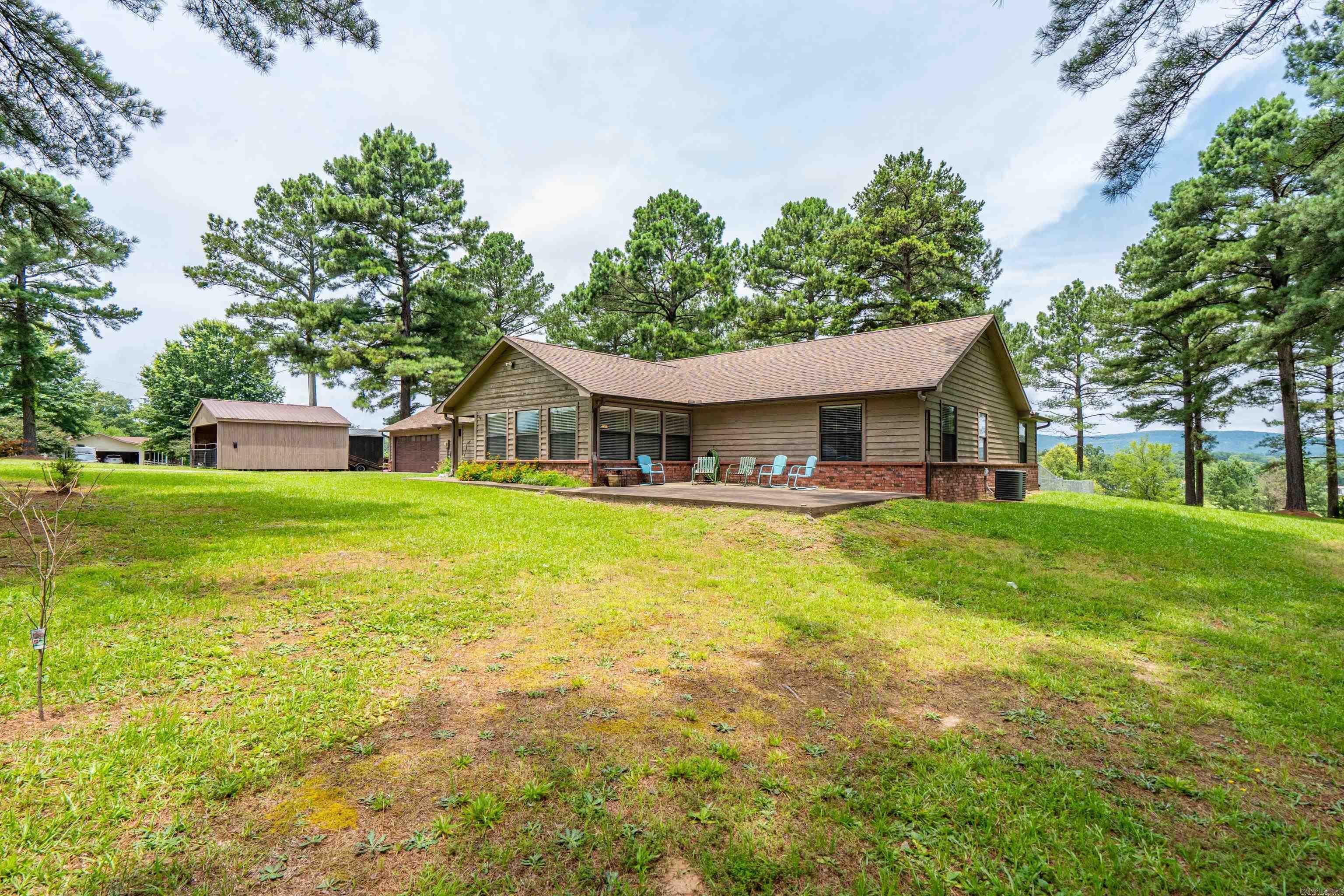 Move-in ready with beautiful mountain views! This solid, well-maintained home offers comfort, space, and incredible storage with six walk-in closets throughout. Enjoy the scenic views year-round from the inviting front sunroom, or relax in the newly glass-enclosed back porch. The spacious living room features a cozy wood-burning stove for cozy evenings.  The very large primary bedroom is a wonderful and ready for you! With three more bedroom and a bonus room you will have the space you need. This well built home offers low utility bills. And the oversized garage is a standout feature, complete with a half bath, attic fan, and plenty of room for vehicles, hobbies, or a workshop. Outside, you’ll find even more value with the wood, site built,gate enclosed, three sided carport and outbuildings, all of which convey with the property. This home has been lovingly maintained and is truly move-in ready, offering the perfect combination of functionality, comfort, and peaceful mountain anc creek views. Roof, refrigerator, hot water heater and wood stove are 4 years old. The home has been set up to hook up your generator for power outages.