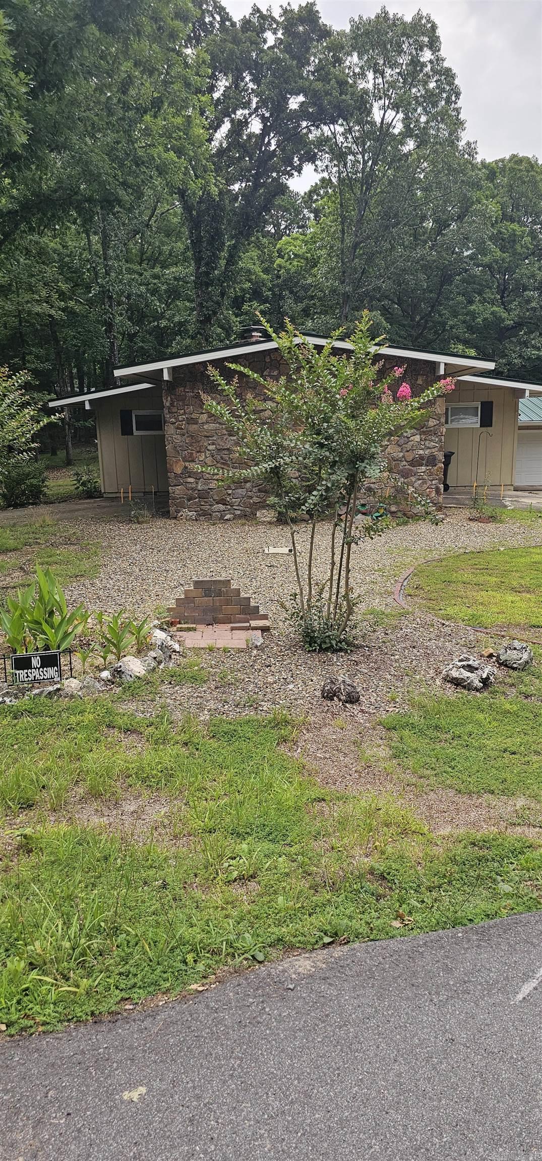 Time to come see this well maintained home with beautiful rock accents inside and out.  Enjoy peaceful living in Hot Springs Village, a gated community that you can experience golfing, swimming, boating, tennis and pickleball.  This 3 bedroom, 2 bath home offers a carport with storage and 2 car garage with more storage and electric garage door.  Covered patio with back fence and room to garden with a metal roof approximately 2 yrs old.  Beautiful prego flooring in a large living/dining area with high ceiling, hallway and bedroom.  Carpet in other 2 bedrooms.  Almost new appliances offer gas range with vent a hood and Bosh dishwasher.  The plumbing has been entirely renovated and approximately 7 yr old AC/Heat.  Beautiful rock fireplace with Buck stove insert recently cleaned.  Call to go see today.