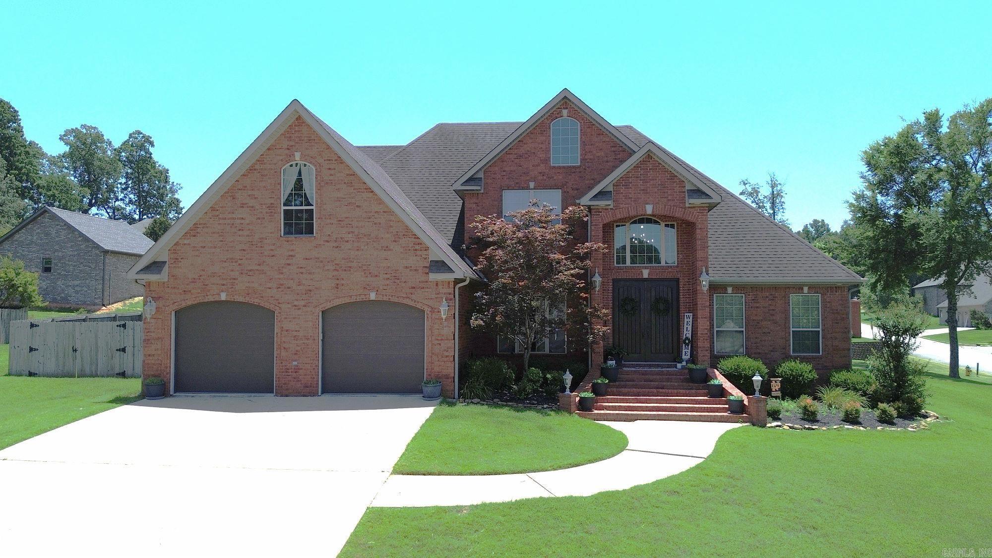Exuding timeless elegance and refined comfort, this impressive 5-bedroom, 3-bath home is perfectly situated on a desirable corner lot in a quiet, walkable neighborhood just minutes from the golf course. Offered at a new price and including a $15,000 flooring allowance, this home presents a fantastic opportunity to personalize finishes to your taste. The main level features hardwood floors in the living and dining areas, anchored by a stylish gas-log fireplace. The well-appointed kitchen offers granite countertops, a walk-in pantry, and a bright breakfast nook. The primary suite is a true retreat with crown molding, a large walk-in closet, and a spa-like bath with a whirlpool tub and separate walk-in shower. A second main-level bedroom with nearby bath access adds flexibility. Upstairs, you’ll find three spacious bedrooms, all with walk-in closets, and a full bath. Enjoy year-round entertaining on the covered patio featuring a gas-log fireplace and mounted TV. Space, style, and value come together in this exceptional home.