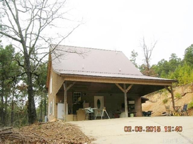 Sold before listed   Feels like a city loft in the country. One of a kind home that you will be proud to own.  Red Oak and pine log walls and ceilings, tile floors, granite counters, wrought iron railings, gas fireplace and so much more.  The entry level features living room with vaulted ceilings, dining, kitchen, large windows for lots of light. The primary bedroom features a private bath with oversized shower and loads of storage.  The laundry features a pantry and closet for hanging clothes.  Second level includes a guest bedroom, bath and sitting room.  There is also a heated and cooled sunroom off the primary suite. Extras include designer ceiling fans, Pewabic Tiles around fireplace, custom cabinetry, leaded glass, wood floors.  Attached 2 car carport, large detached garage for parking, workshop, craft area, storage and so much more. Concrete retaining wall and outside storm cellar.  Metal roof.  Close to shopping yet the privacy you crave.  There is also an electric gate for security.