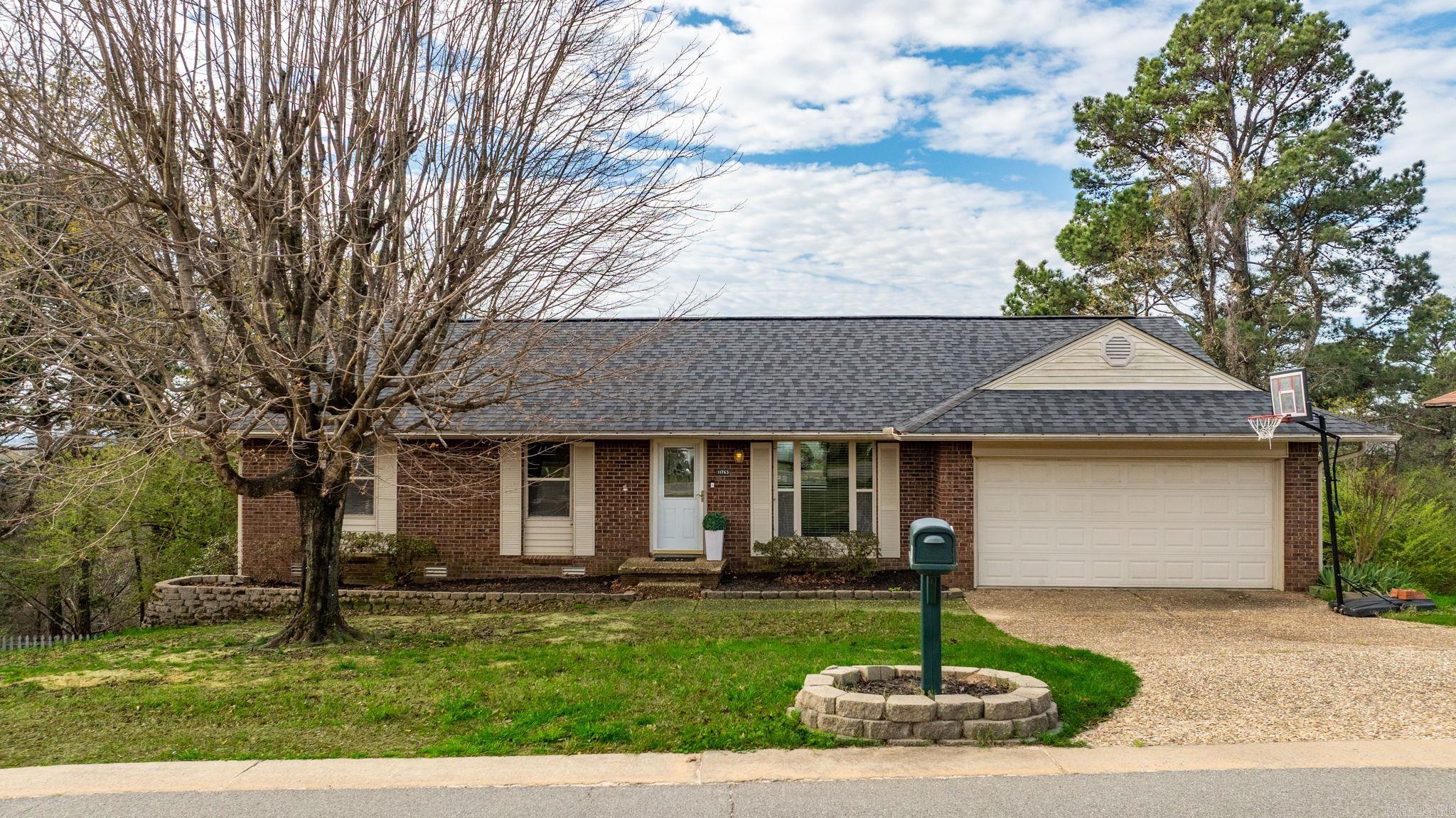 Experience stunning views of the Little Rock skyline and surrounding green space from this beautiful Walton Heights home. Designed to live like a one-level home, the main floor features an open-concept living and dining area that flows seamlessly into the kitchen. The kitchen offers wood cabinetry, granite countertops, stainless steel appliances, and a stainless-steel refrigerator.  Just off the kitchen is a flexible space—perfect for an office, hobby room, or cozy breakfast/TV room—complete with a large picture window. Upstairs, you’ll find the guest bedrooms with a full bath, along with the spacious primary suite featuring a beautifully updated bath with tan subway tile. Step through the sliding glass doors onto a large deck ideal for outdoor living, dining, and entertaining while taking in the incredible views. The lower level provides excellent versatility with in-law or teen quarters, including a large bedroom, full bath, and generous den accented by a barn door. Off the den is a storage room with an exterior door leading to a dog run. Additional features include a two-car garage and ample storage throughout.
