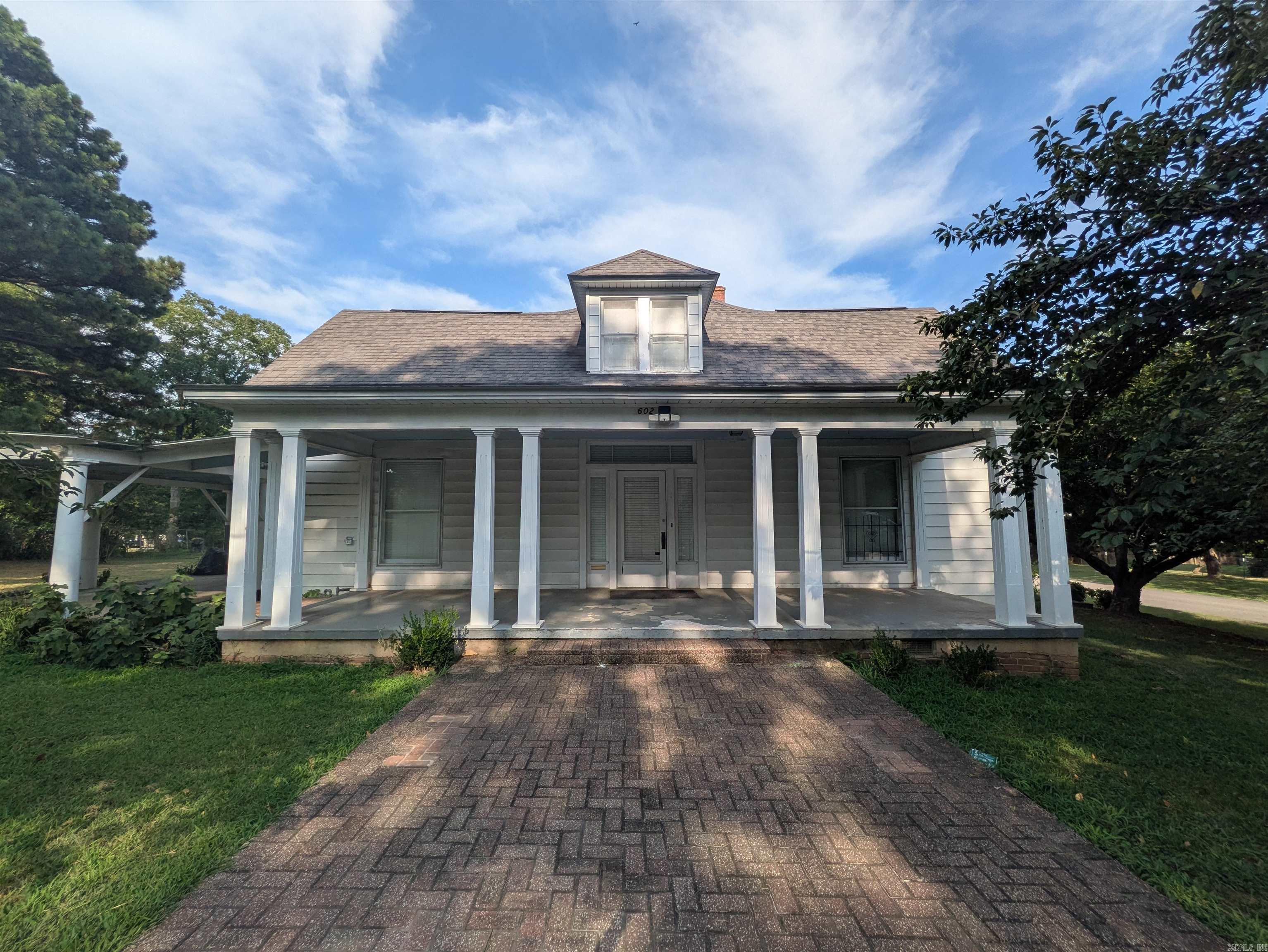 Timeless character and generous living spaces define this distinctive two-story Atkins home. Offering 3 bedrooms, including one upstairs, 2.5 bathrooms with one upstairs, plus formal living and dining areas, the home provides plenty of room for everyday living and entertaining. Hardwood floors, tall ceilings, abundant natural light, detailed trimwork, decorative fixtures, and an eye-catching staircase showcase its classic craftsmanship. Additional upstairs space offers flexibility for an office, hobby room, playroom, or storage. The kitchen and baths retain vintage character with opportunities to update and personalize over time. Outside, a broad covered porch, mature trees, expansive lawn, and covered parking add to the appeal. With operational HVAC, the home is move-in ready while offering abundant potential for future improvements. If you appreciate historic architecture, spacious rooms, and original details, 602 Avenue 2 NE deserves a closer look.