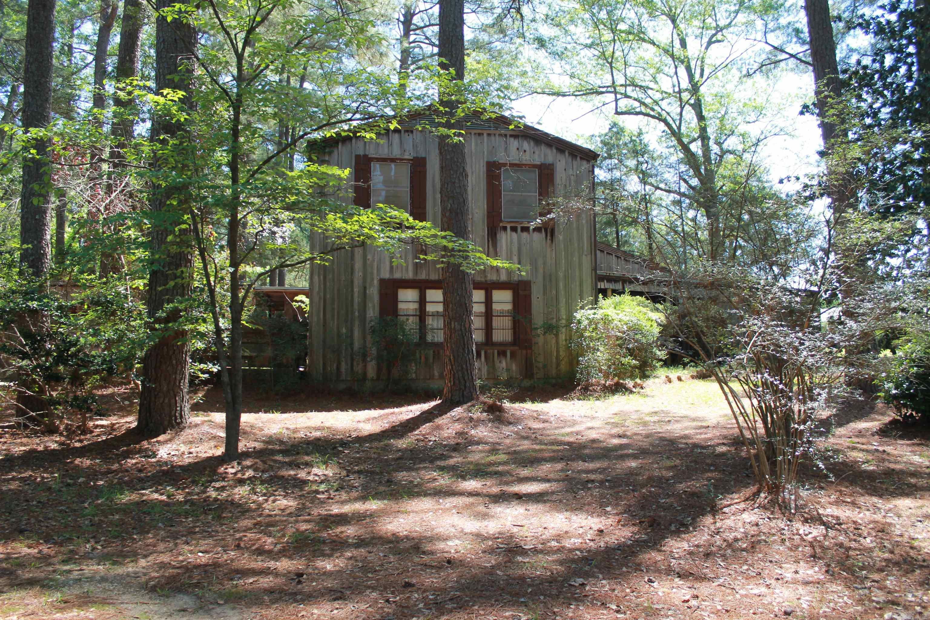 Contemporary cedar home with barn, garden spot, small pond, and large cleared area that could be pasture for animals located just minutes from town. HOUSE TO BE SOLD AS IS;