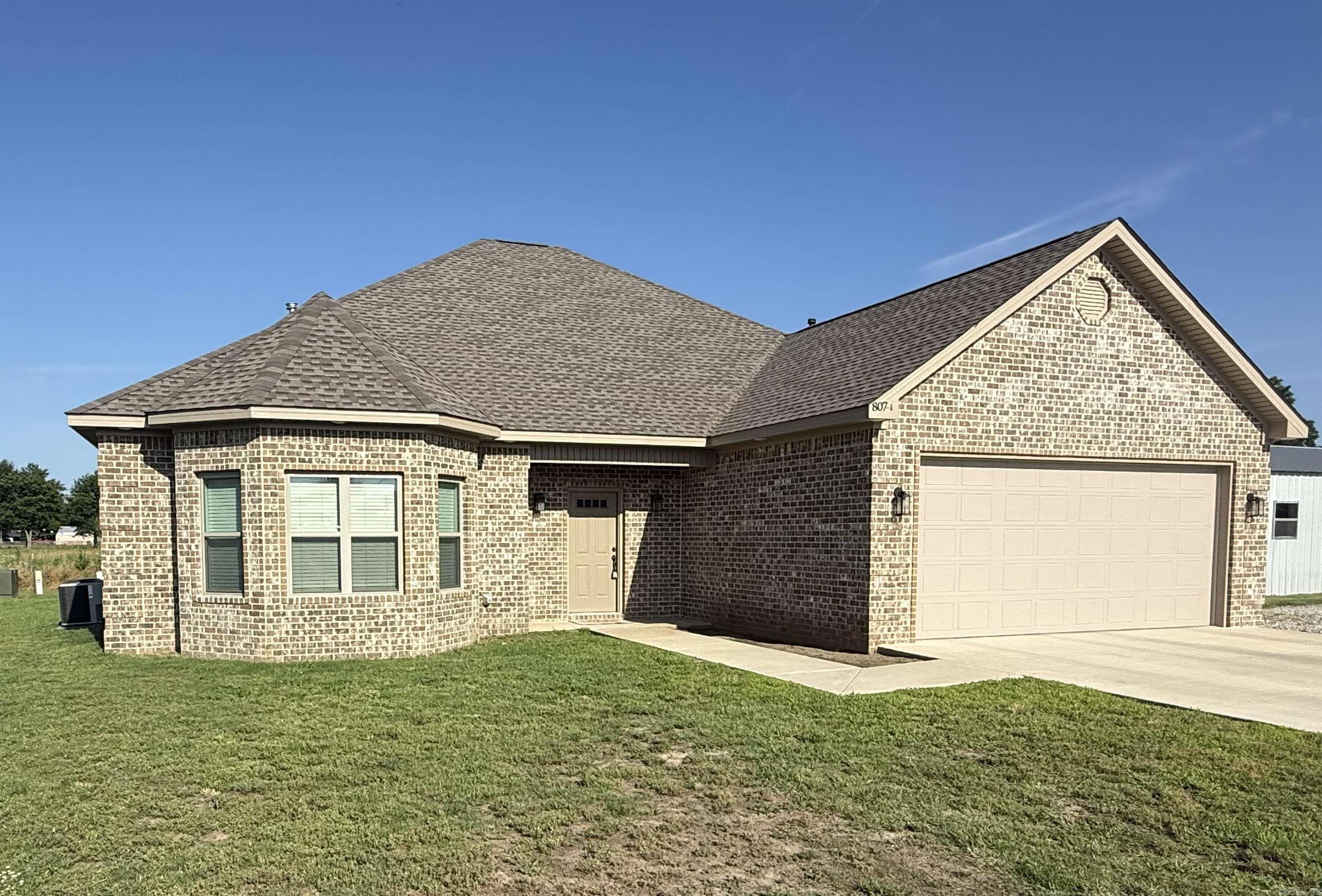 Built in 2024, this 3-bedroom, 2-bath home offers 2,061 sq ft of thoughtfully designed living space. The open floor plan features 10-foot ceilings in the living room, arched entryways, LVP flooring, and a gas fireplace with custom built-ins. The oversized kitchen is the centerpiece of the home, featuring abundant cabinetry, stainless appliances, a large bay window, and an impressive 7.5-foot island with bar seating. The split floor plan includes a spacious primary suite with double vanities, a large tiled walk-in shower, and a reinforced safe-room closet. Enjoy outdoor entertaining year-round from the covered back porch complete with a gas hook up for grilling. Lastly, don't forget about the whole house Generac generator. Modern construction, functional design, and move-in ready.