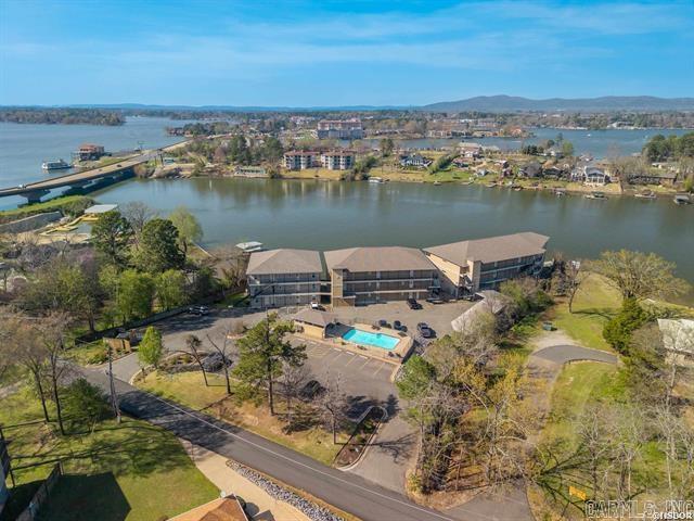Experience lake living at its finest with this beautiful walk-in level condo in Hot Springs! Featuring 2 bedrooms and 2 bathrooms, this move-in-ready unit offers the perfect blend of comfort and investment potential. Step inside to find brand new luxury vinyl flooring and granite countertops throughout, giving the space a fresh, modern feel. The open layout flows seamlessly to a giant private balcony overlooking the main channel of Lake Hamilton —perfect for morning coffee or sunset views. This condo has been successfully used as a short-term rental for several years, boasting a strong rental history and excellent condition. Whether you’re looking for a personal getaway, full-time residence, or income-producing property, this one checks all the boxes. Don’t miss your chance to own a piece of lakefront paradise!