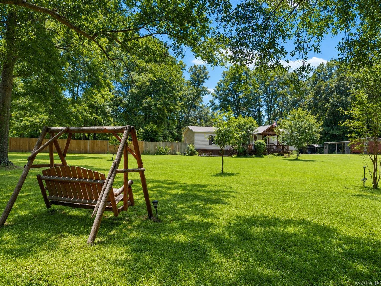 If country living on a little acreage is what you have in mind, then this house may be the one! Different varieties of trees and bushes have been planted to add some character to the landscaping. With flowers, fruit, and pecans, you'll love your yard. With porches and decks on the front and back, outdoor living is great here! When you decide to go inside you will love the open layout. The thoughtful built in entertainment center give you space to free up more space and less cords. With a bar seating island, and dining space, you have plenty of room for indoor entertaining. Storage is located off the laundry room that makes a great pantry. The bedrooms are great sizes with spacious closets and bathrooms. If you like to open the door and let the dogs run free, don't miss out on seeing the big, fenced backyard. Comfort, space, and convenient to town!