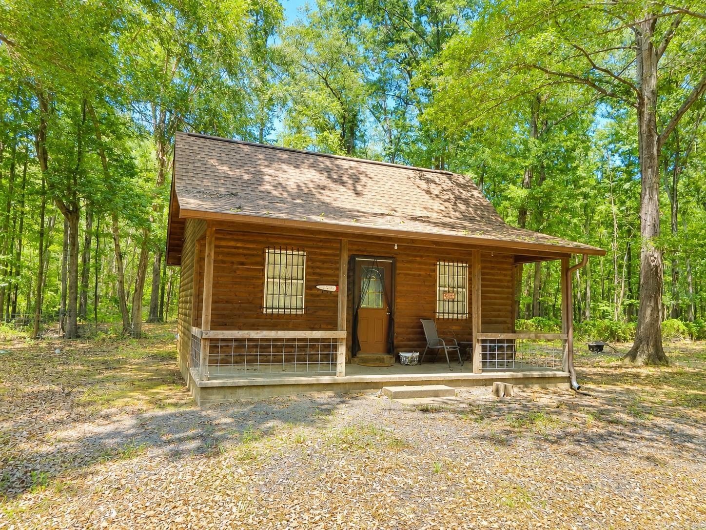 Tucked away on 3.36 peaceful, wooded acres in Heber Springs, this charming cabin offers the perfect blend of privacy, comfort, and functionality. Surrounded by mature trees and fully fenced, the property provides a serene setting with plenty of room to enjoy nature.  Relax on the 16' x 6' covered front porchs. Inside, you'll find a warm, rustic interior featuring numerous recent updates, including new flooring, a new roof, a new 2-ton mini-split HVAC system, upgraded bathroom ventilation, and 16 inches of added insulation for year-round comfort and energy efficiency. The exterior is equally impressive with copper gutters.  A 12' x 20' horse barn is perfect for livestock or hobby farming, while the 22' x 44' RV shed with electricity offers excellent storage for your RV, boat, or equipment. An added bonus is two additional RV hookup sites, each equipped with water, electricity, and septic, offering incredible flexibility for guests, rental income, or multiple RVs. Conveniently located just minutes from the world-famous Little Red River and Greers Ferry Lake.