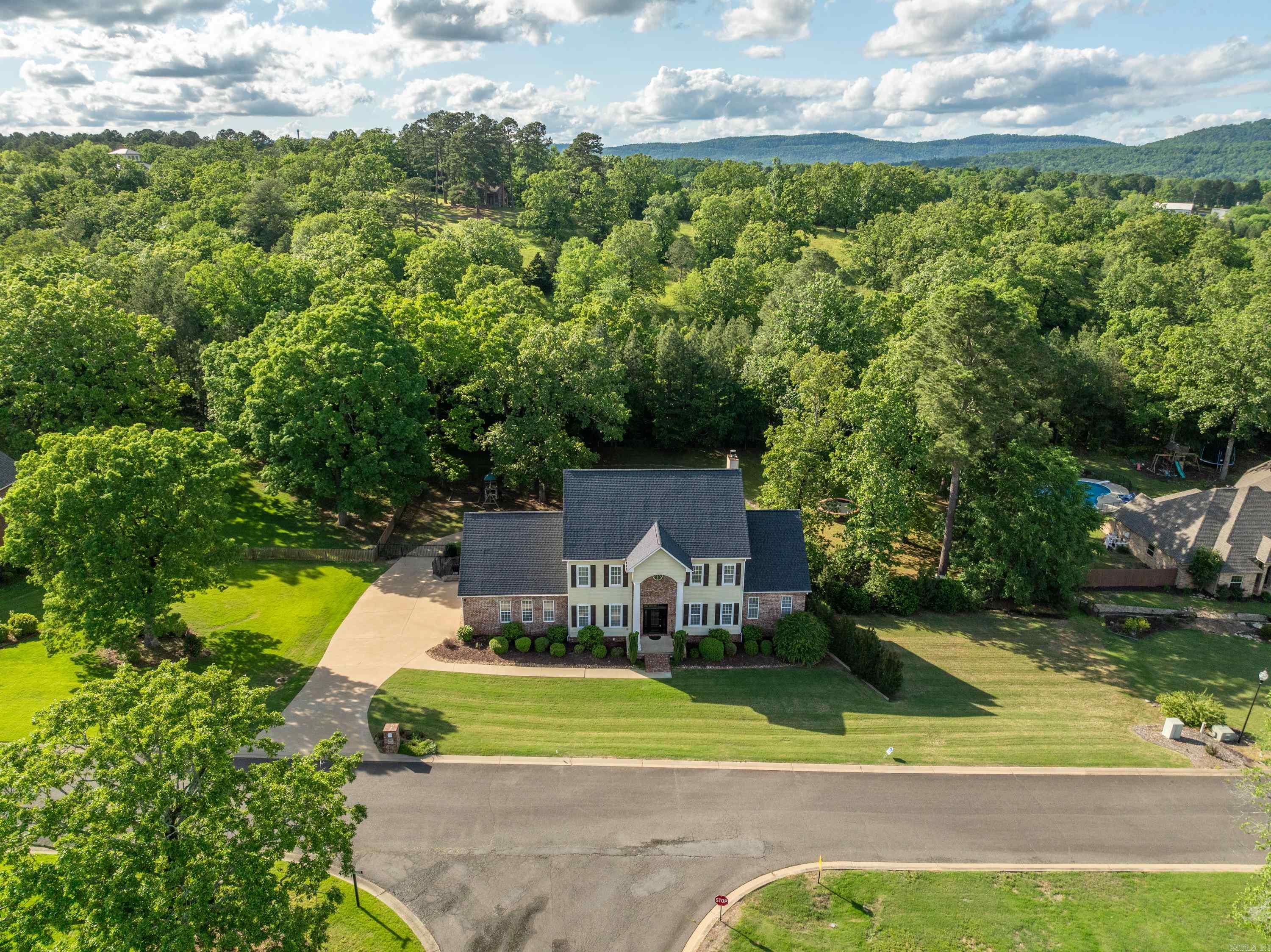 Perfectly positioned on a full acre within Quail Ridge Estates. This 6-bedroom, 4.5-bathroom home stands as a testament to luxury & seclusion. This home features an array of living spaces ideal for social events, including a game room with a bar, pool table & hot tub. The generous primary suite, offers seamless access to the kitchen, living areas, & office. While the ground floor presents an ensuite bedroom, creating a secluded retreat for guests or a comfortable option for multigenerational living.  Each level offers abundant storage & laundry facilities for your convenience. Parking is a breeze with a three-car garage situated on the main level & an additional boat garage/workshop on the lower-level. The backyard will become your favored retreat, a secluded and tranquil haven. Enveloped by towering trees, it boasts a lovely inground pool& fountain for a tranquil, serene escape for relax. Quail Ridge is notably one of the more community minded subdivisions in Hot Springs offering community wide events on holidays and lower HOA dues than most. Put this home on your list you have to see it in person to truly appreciate it. (some photos are virtually staged)