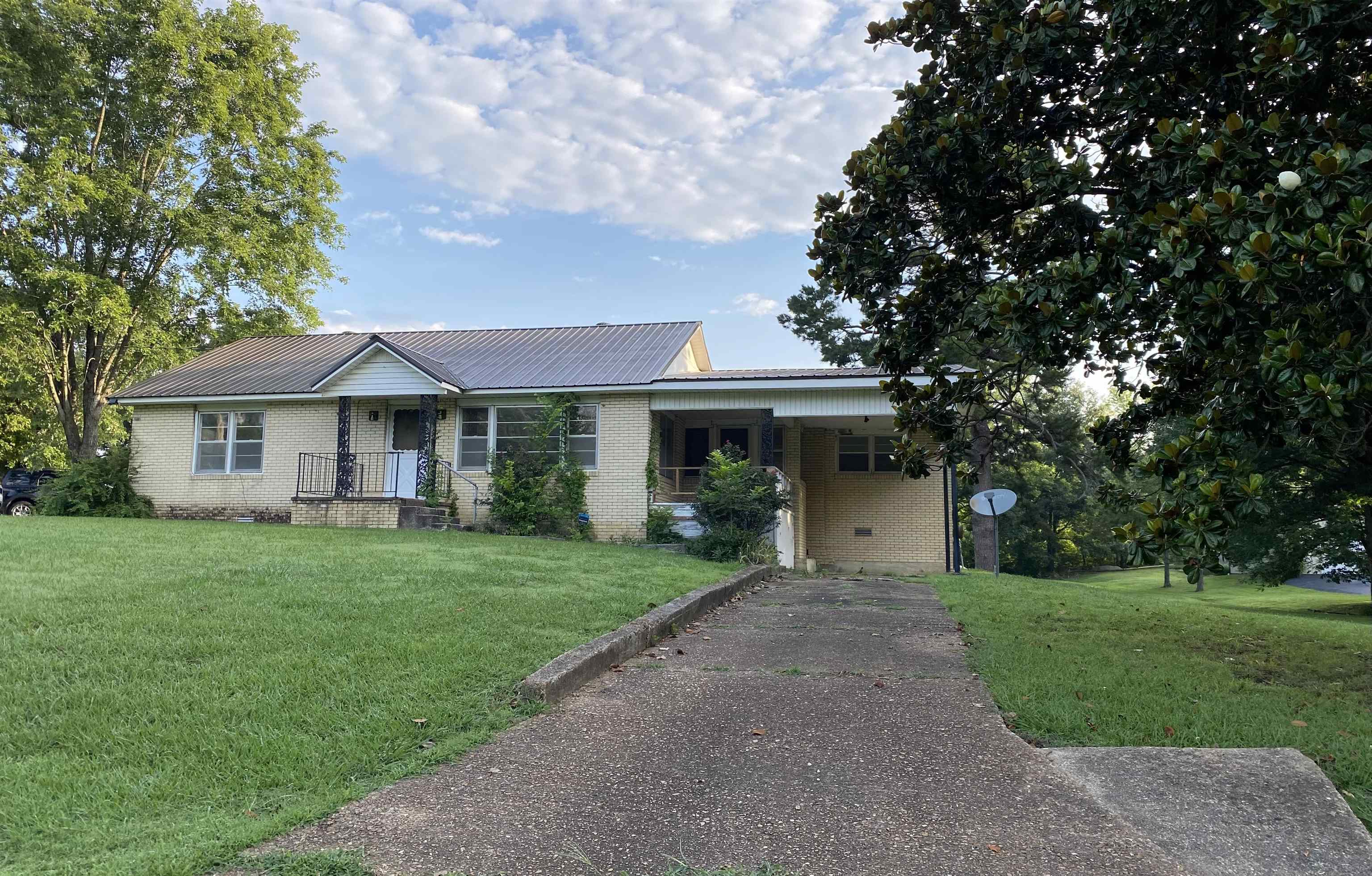 This brick home sitting on 2.9 m/l acres offers 4 bedrooms, 2 bathrooms, and plenty of space for comfortable living. Situated on a corner lot, this property features convenient parking in both the front and back of the home.  Inside the home has spacious living areas and touches of character throughout the home. Whether you’re looking for your first home, a place to downsize, or an investment opportunity, this property offers plenty of potential.  Outside features a small shop/tool shed with an attached lean to, along with a screened in back porch and a covered front porch perfect for relaxing. A covered carport on the back of the home adds extra convenience, and the large yard provides plenty of outdoor space to enjoy.  With its attractive curb appeal and convenient location, this home is ready for its next owner. Don’t miss the opportunity to see all this property has to offer. Schedule your showing today!