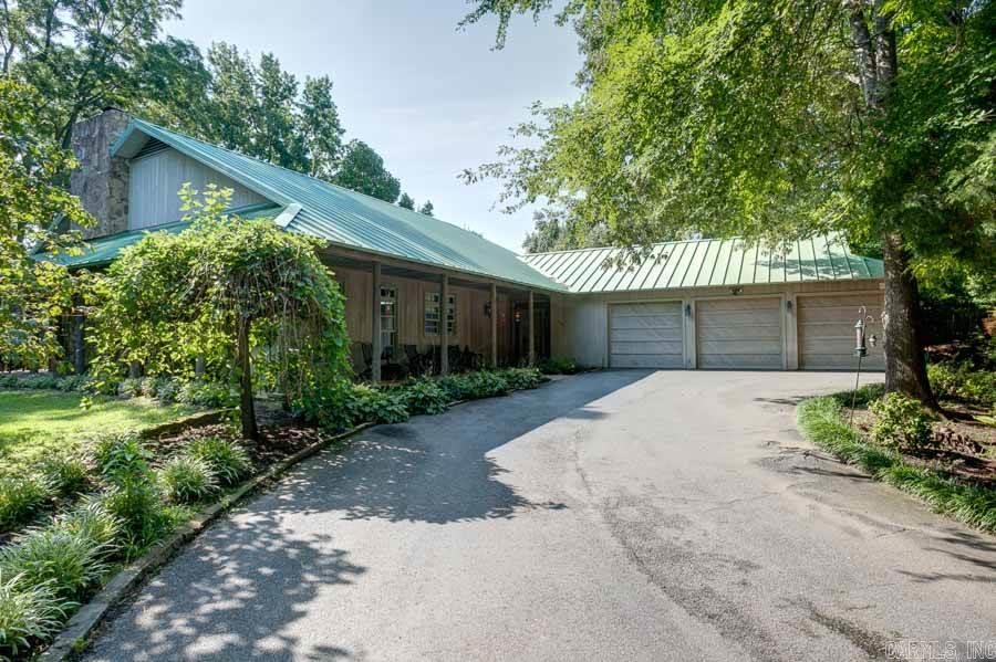 Custom built home w/country feel minutes from shopping & dining. Cypress wood exterior, metal roof & lush landscaping gives this home a tranquil setting. Deep porches on 3 sides w/ceiling fans & native stone perfect for entertaining & watching wildlife. Inside are large windows, DR, Laundry, huge vaulted den w/impressive stone WBFP, wood ceilings, floors & beams. Wood walls, Native stone floors, veranda w/stone steps to pool overlooking lake. Thermador stove, Sub-Zero frig, pantry/wine cellar. Come See!