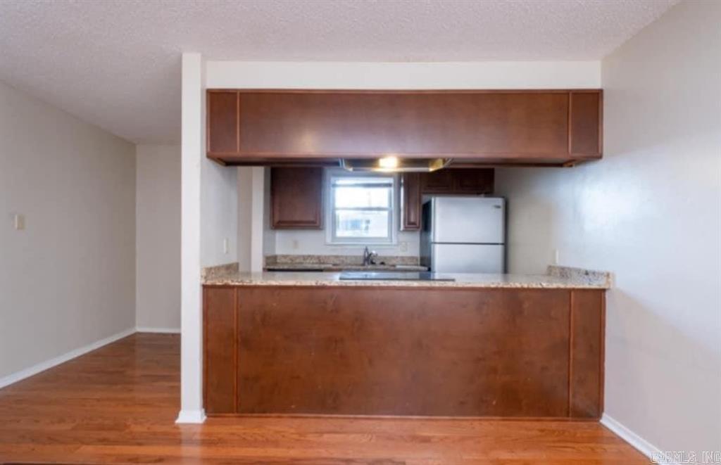 Welcome to this ground-floor 1 bedroom, 1 bathroom condo in the desirable Coolwood Condo community, conveniently located just off Cantrell Road. The unit features wood and tile flooring throughout and slab granite countertops in both the kitchen and bathroom for a clean, modern look.  The kitchen comes fully equipped with all appliances, and a washer and dryer are included, conveniently tucked into a bathroom closet. Low utility costs with only electric and cold water billed to the owner—no gas, while the HOA covers hot water and trash service.   Enjoy your private deck overlooking the pool and beautifully landscaped grounds. The property also offers assigned covered parking located at the rear of the complex, all within a fully gated community.  Ideally situated near restaurants, shopping, biking trails, and downtown, this condo offers both comfort and convenience in a prime location. 10 units can be purchased as a package. AGENTS SEE REMARKS