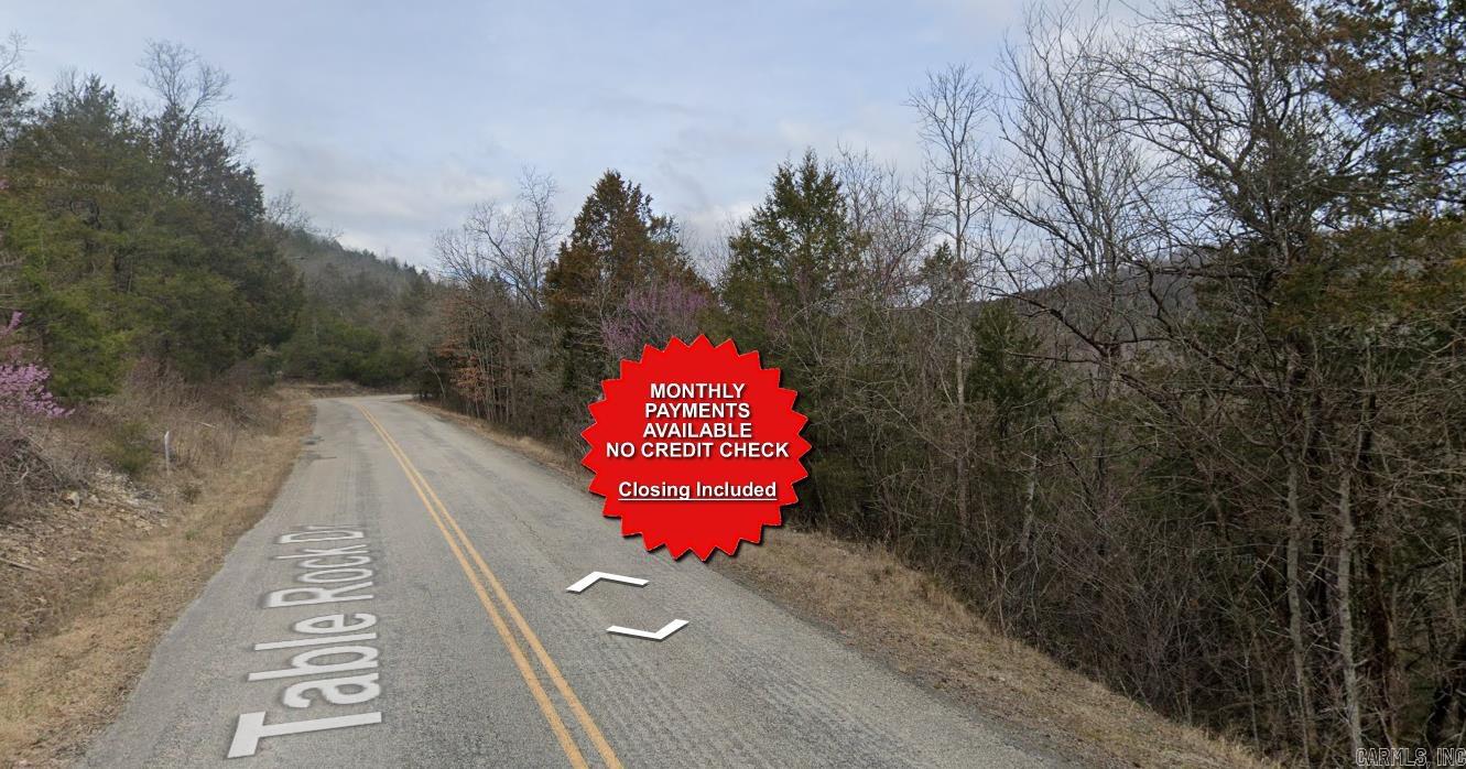County appraised value $7500. Owner-finance available for easy terms. You cannot camp or park a trailer on the lot. No mobile homes but other types of housing is allowed. Not far from Eureka Springs, the Missouri and Oklahoma border and very scenic mountain area. Public sewer and water at the paved road and electric not far. Nice lot to develop or hold for future value. Owner/agent. Quit claim deed conveys. Closing costs are included. Bulk land sales specialist with the best land prices in Arkansas. Over 10 years, as a licensed Realtor, selling land.  Parcel ID# 320-01488-000