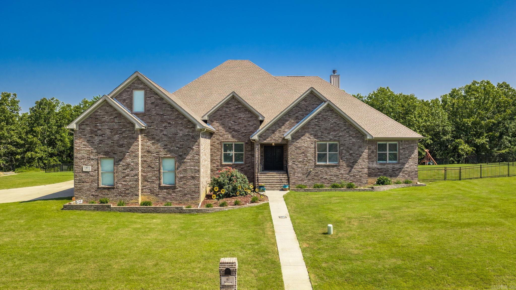 Stunning two level custom-built brick house with a large bonus room (35x13 ft) upstairs. Lives like a one-level with all bedrooms on first floor. On gated road. Beautiful home with exceptional window and door trim work. This home interior trim is better than most $1M+ homes. Wood plantation shutters on all windows. Built in 2022. Very, very large rooms, see dimensions in the room information section. All 4 bedrooms have ensuite bath rooms. Formal dining area (18x13 ft).  Large family room has wood burning fireplace. Very large laundry room (16x10 ft). Half bathroom easily accessed by visitors. Hard wood floors throughout with tile in bathroom and laundry. Principal bedroom (23x15 ft) has electric fireplace. Principal bathroom (18x11 ft) has tub and walk-in shower.  Very large walk-in closet. Central vacuum system throughout. Very, very large covered patio (47x23 ft) with wood burning fireplace.  Large fiberglass pool that was just completed with beautiful landscaping. Fully fenced back yard. Enjoy your pool in privacy in this lot that backs to wooded green space.  Large corner lot with side entry 3 car garage. Exterior trim lights that can be set to different colors.