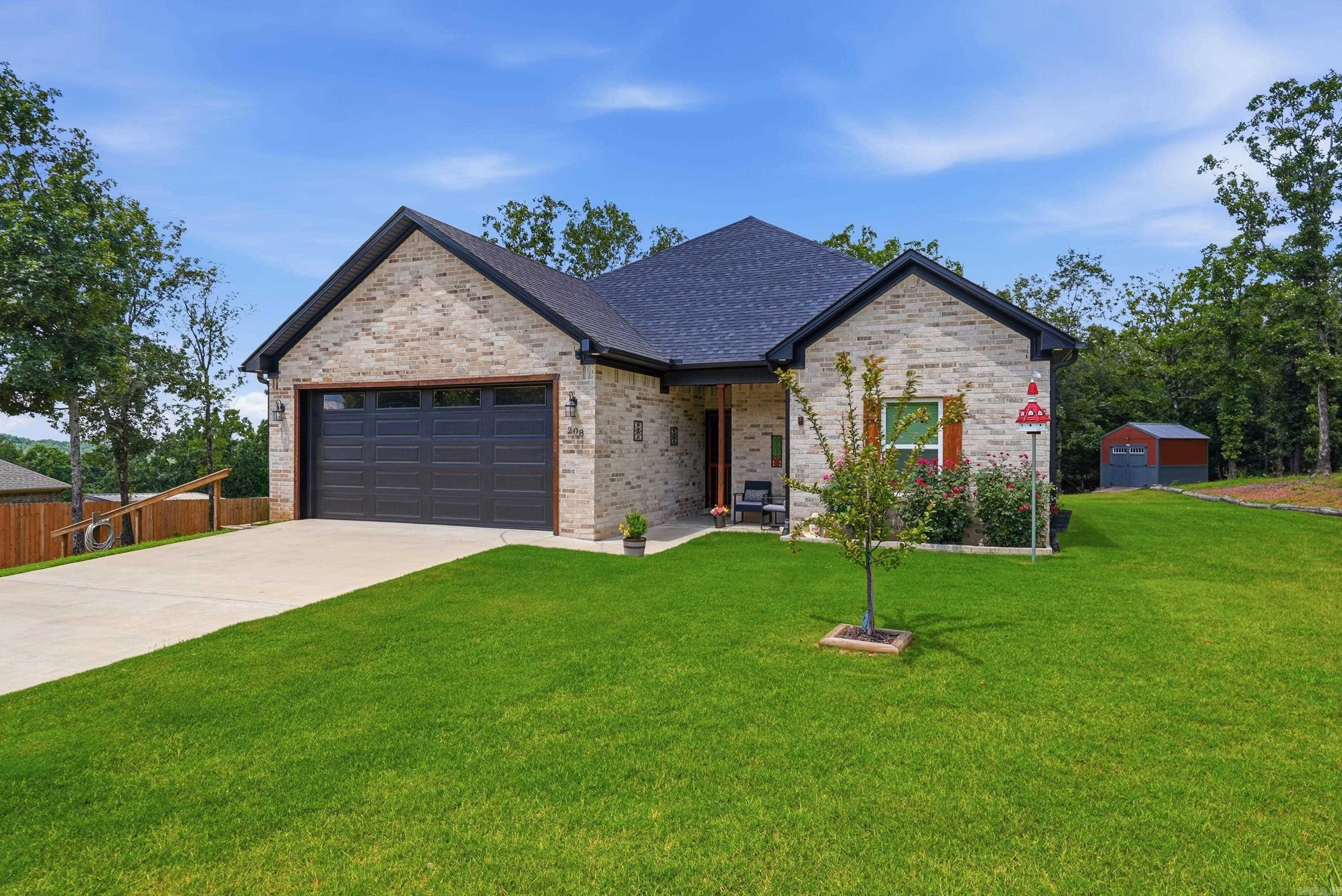 Exciting almost-new construction with all the upgrades already done for you! Enjoy peaceful country living just minutes from Greenbrier in this move-in-ready home packed with thoughtful improvements. The open floor plan is perfect for entertaining, bringing everyone together with a spacious living area and a kitchen featuring abundant cabinetry, a large island with seating, and a window overlooking the private backyard.  Relax on the extended covered deck, gather around the fire pit, or enjoy the fully fenced backyard that backs to woods for added privacy. The owners have also added a 10x12 storage building, RV parking pad, lush landscaping and sod, decorative shutters, wood accents, an electric fireplace, and extra cabinetry in the laundry room.  Luxury vinyl plank flooring flows throughout, and the split-bedroom layout offers privacy for the spacious primary suite with a roomy bath and two walk-in closets. Every upgrade has already been completed, giving you the benefits of newer construction without the extra expense. This home is truly move-in ready!