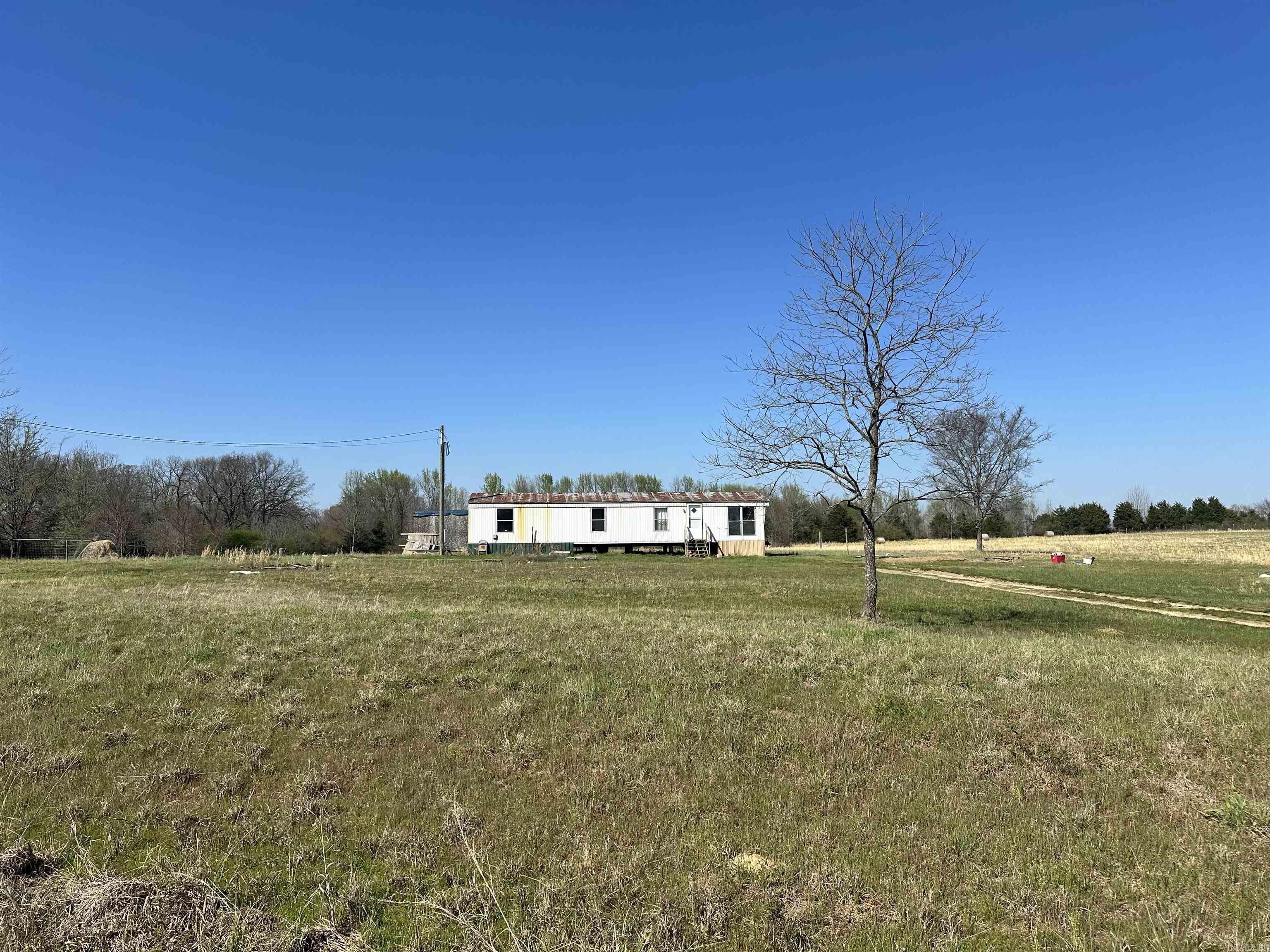 This 8-acre property in Allen Mountain Estates is mostly cleared with a few scattered trees. It is all level and usable land with water and electric in place for the 2-bedroom mobile home. About 4-acres is being used for hay and it is fenced on two sides. It has county road frontage with a fire station only two lots down. The deer are plentiful and some really big bucks roam this area.   If you are ready to get away from the hustle and bustle of the city this is a quite, peaceful place with incredible sunsets. It is conveniently located just 8-miles from Pangburn, 12-miles from Searcy, and it's only 6.3 miles to the Moanghan-Womack access of the Little Red River! You could be on the Little Red trout fishing in 15 minutes!   Schedule your showing today. Call Marty Sikes @ 501-450-0963