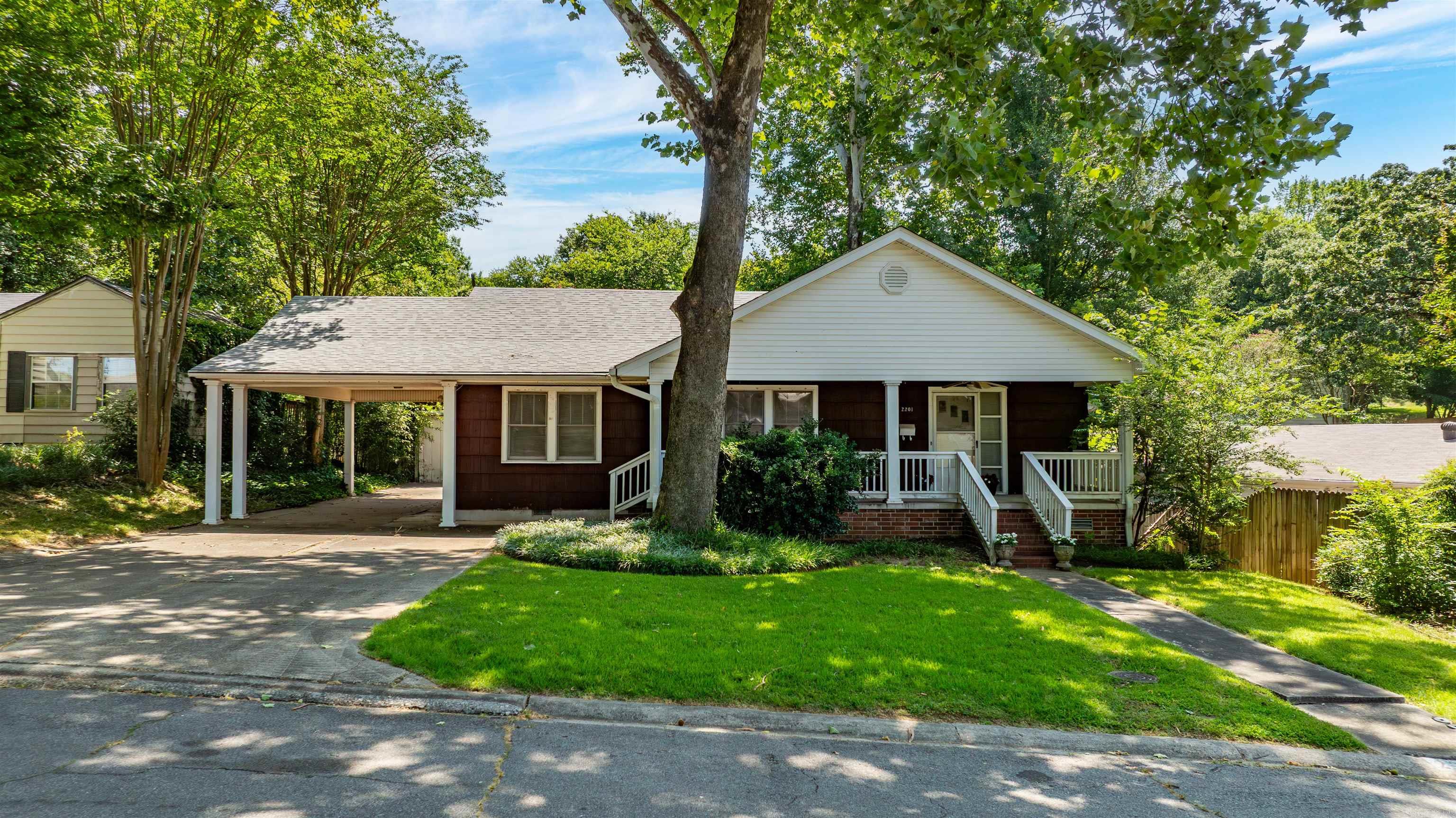 Fantastic opportunity to remodel or build in a desirable location! This 3 bedroom 2 bathroom home offers a functional floor plan with spacious living areas, including a large den with vaulted ceilings, a decorative brick fireplace and glass doors leading to the backyard. The kitchen is open to the den, and the unfinished basement with an exterior entrance provides additional space (400 sqft) and endless possibilities. Exterior features include a fabulous covered front porch, carport, deck and two storage buildings. Just a short walk to Heights shopping, restaurants, Jefferson Elementary and more! Home is being sold as-is. See agent remarks.