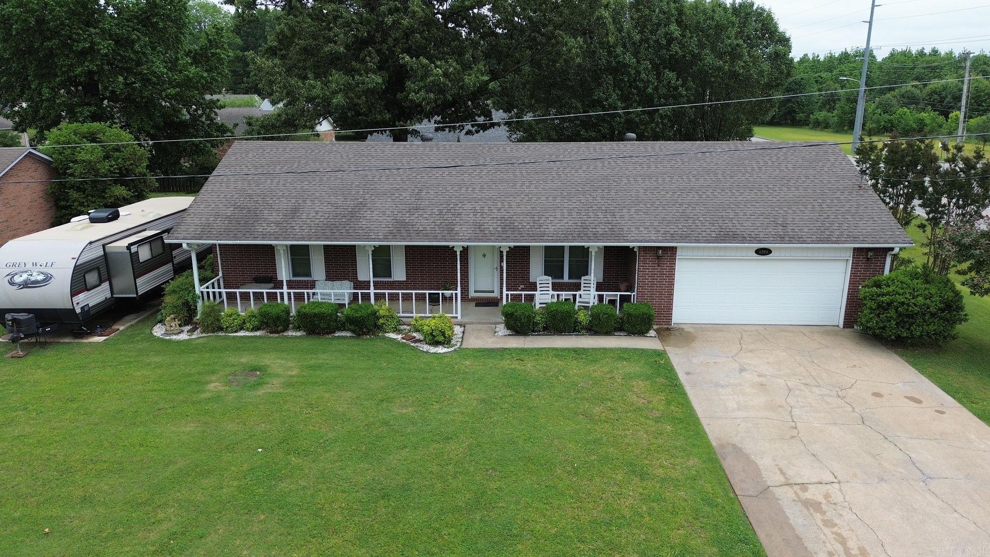 This well-maintained 3-bedroom, 2-bath brick home sits on a desirable corner lot and features an inviting open floor plan that creates a spacious and comfortable flow for everyday living and entertaining. The kitchen is designed for functionality and gathering with a breakfast bar, center island, and pantry for extra storage while overlooking the main living area. Enjoy relaxing mornings on the large front porch or spend evenings entertaining on the spacious back deck. Outside, you’ll find a 20x30 shop building with electricity—perfect for hobbies, storage, or a workspace—as well as a 35-foot parking pad ideal for your camper, RV, or boat. Recent updates provide added peace of mind, including a roof replaced in 2021, new windows in 2025, and a water heater installed in 2024. This property offers the perfect combination of space, updates, and functionality!  See agent remarks.