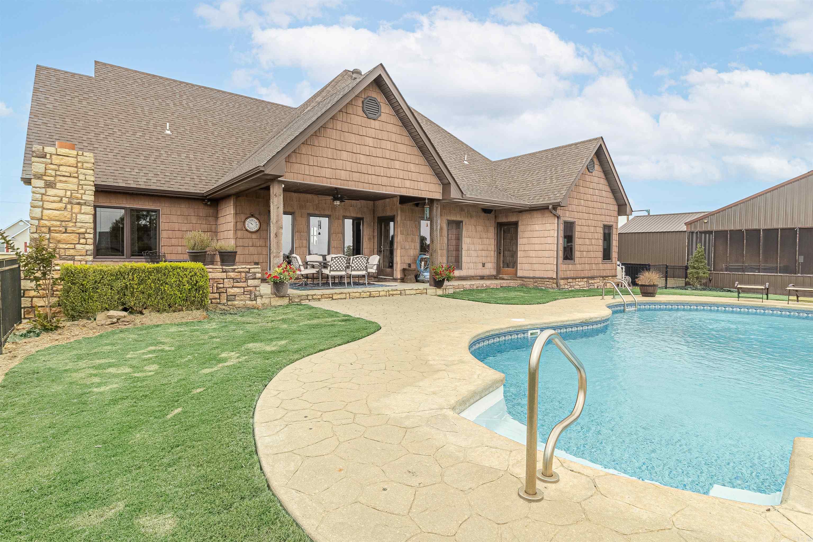 Exquisite 3-acre estate with a luxurious 3-bedroom home, pool, and versatile amenities. Discover private living within this exceptional estate nestled in NE Arkansas. The main house, a meticulously designed 2128 sq ft residence, boasts 3 bedrooms and 2.5 baths. This property goes beyond the ordinary with additional amenities that elevate it to a league of its own. The main house offers a spacious and open floor plan with stained concrete floors, a stone fireplace, and rich walnut-stained built-ins.     In fact, you'll see that the interior was thoughtfully designed with coordinating walnut-stained doors, walnut-stained shaker cabinets, wood dining room columns, and baseboards. The kitchen features granite counters, stainless steel appliances, pearlescent backsplash tiles, and abundant storage space perfect for any chef.     The primary ensuite boasts dual vanities, a roomy walk-in closet, and a custom-tiled shower. Step outside to discover an outdoor paradise consisting of a covered patio area with a grand stone fireplace that overlooks a sparkling saltwater pool enclosed by a wrought iron fence.