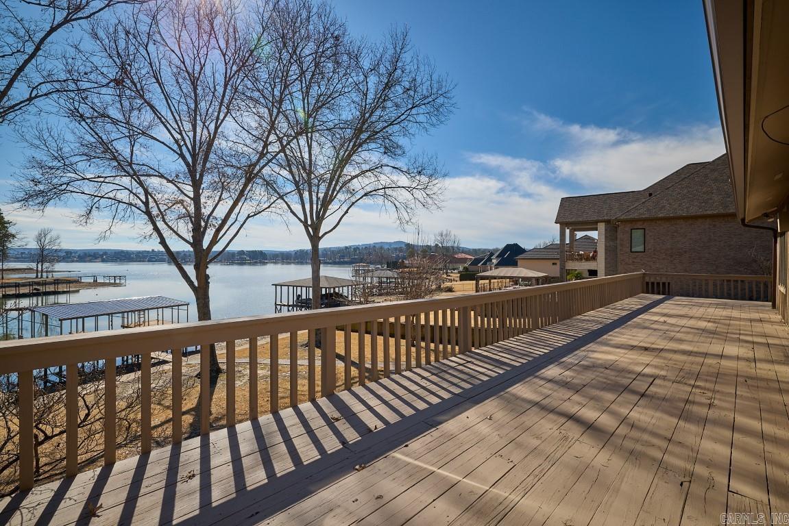 This stunning property boasts beautiful views and direct frontage on Lake Hamilton, offering a picturesque and serene setting. Located just minutes away from various amenities, accessible by car and boat, this residence provides the perfect blend of tranquility and convenience. The property features spacious main and lower living areas, providing ample space for comfortable living and entertaining. The lower level also includes a separate outside entrance, adding to the convenience and flexibility of the space. Elegant oak floors and vaulted ceilings enhance the interior aesthetics, creating a warm and inviting atmosphere throughout the home.  Enjoy the cozy ambiance created by two stunning stone fireplaces, perfect for relaxation and gatherings during cooler evenings.  The property is equipped with a lawn sprinkler system, ensuring the maintenance of lush and well-kept landscaping.  A covered double boat dock with a boat lift provides a secure and convenient space for watercraft. Additionally, the dock includes a swimming deck and a fishing pier, offering recreational opportunities right at your doorstep. Owner is Arkansas licensed Realtor.