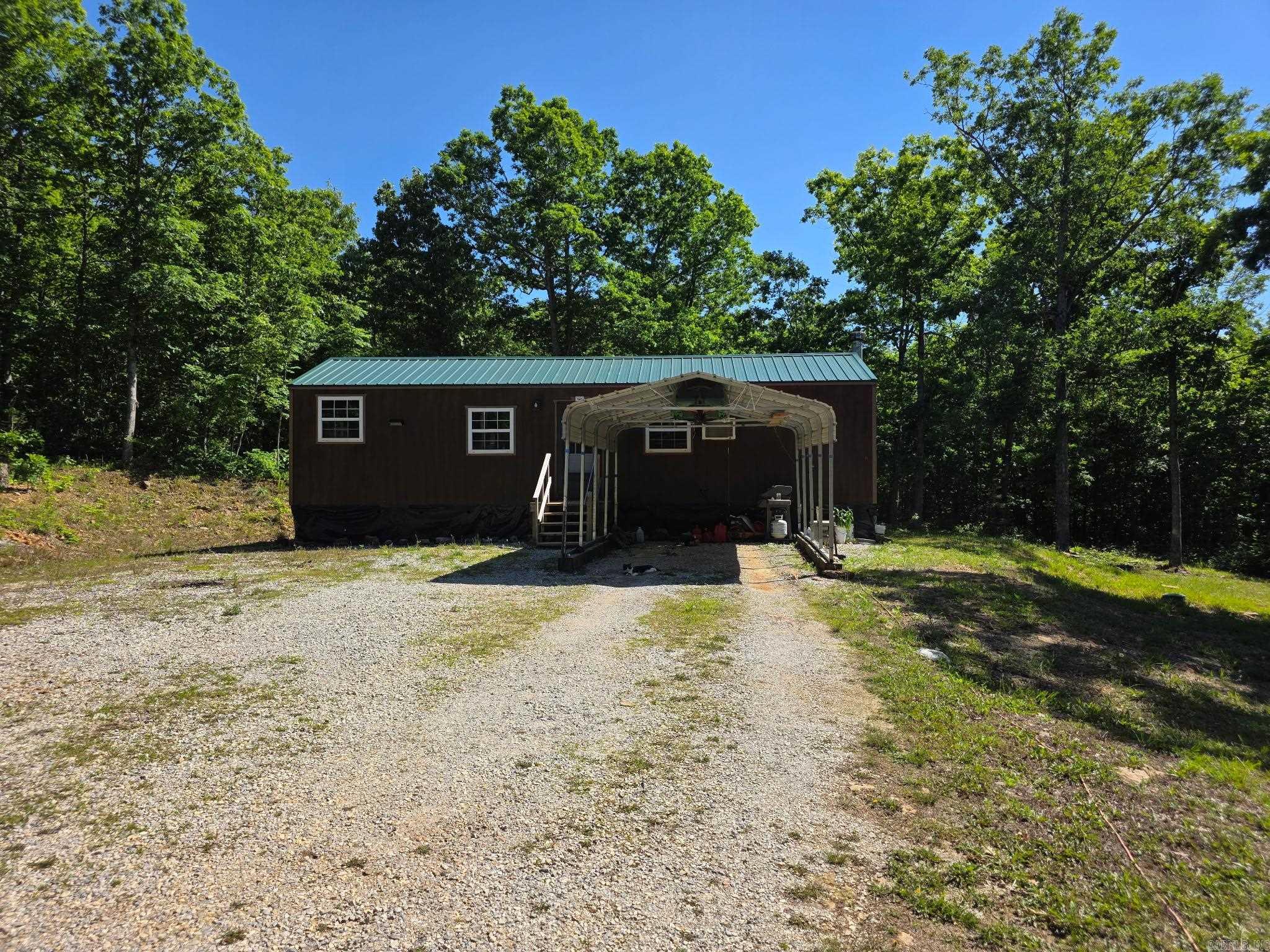 Motivated seller!!! Cabin with acreage in the beautiful Ozarks!  Priced to sell! All the hard work of developing this 18-acre MOL tract has already been done! The spacious cabin is ready to make your own with just over 1000 sq ft, a large 14X40 open concept living/kitchen that could be divided to add a 2nd bedroom, a master with his/her walk-in closet, laundry/pantry room, & a large bathroom. The mostly wooded acreage has gorgeous large native stone ledges, walking & ATV trails, mushrooms, elderberries, muscadines & Little Raccoon Creek is only 10 ft from the back property line! Private septic, 4 frost-free water hydrants, public water, 50amp RV hookup, generator wired, PEX plumbing, foam insulation, large propane tank, nice new chicken coop, & gravel driveway. The cabin is fully functionable & currently owner occupied but the walls, ceiling, & flooring are unfinished. Additional adjoining acreage is available for sale. Call today!