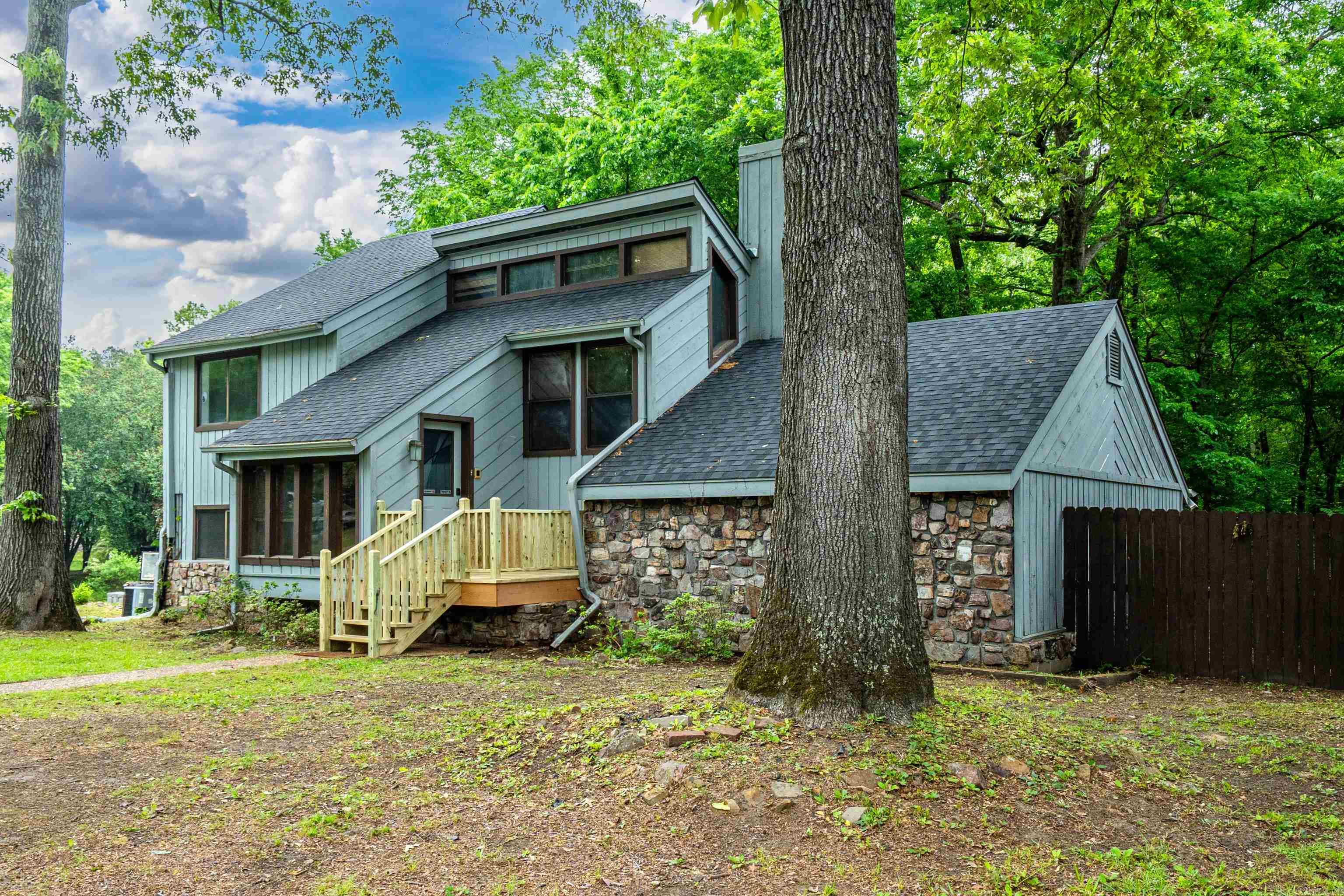 This thoughtfully updated split-level home is full of character and ample storage throughout. It features a striking floor-to-ceiling fireplace in the living room that creates a cozy focal point. On the opposite side, in the master bedroom, the double-sided fireplace brings warmth and charm against a lovely wood feature wall. Step outside to enjoy the spacious back deck, perfect for morning coffee or easy entertaining under the stars.  The lower level offers a wealth of versatile options with its own exterior access. Featuring three separate rooms along with a shower and sink, it’s ready to adapt to your needs—whether that’s a home gym, game room, workshop, crafting area, or generous storage space. Located conveniently near the college campuses, this versatile lower level also presents an excellent opportunity for rental income or guest quarters. It’s truly an ideal canvas to create additional living space or an income-producing unit, adding real value and flexibility to the home.