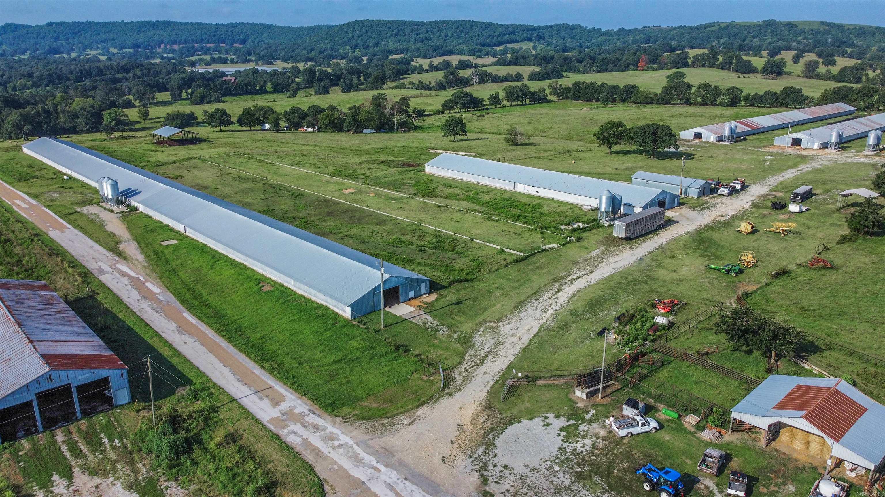 Marion county farm previously ran as a turkey farm could be updated to still run turkeys or chickens. Five barns totaling 120,000 sq ft sitting on 30 pasture acres with a pond all fenced and cross fenced.  There is one 720x50 footing that could have another barn.  Workshop with 3 phase power and bathroom along with 5 - 1000 gallon water tanks. Both city water and a well (40 gpm). Houses are heated with propane. Hook ups for a home or trailer as a residence on site. Separate carport for equipment and a large stacking shed for hay or other storage.