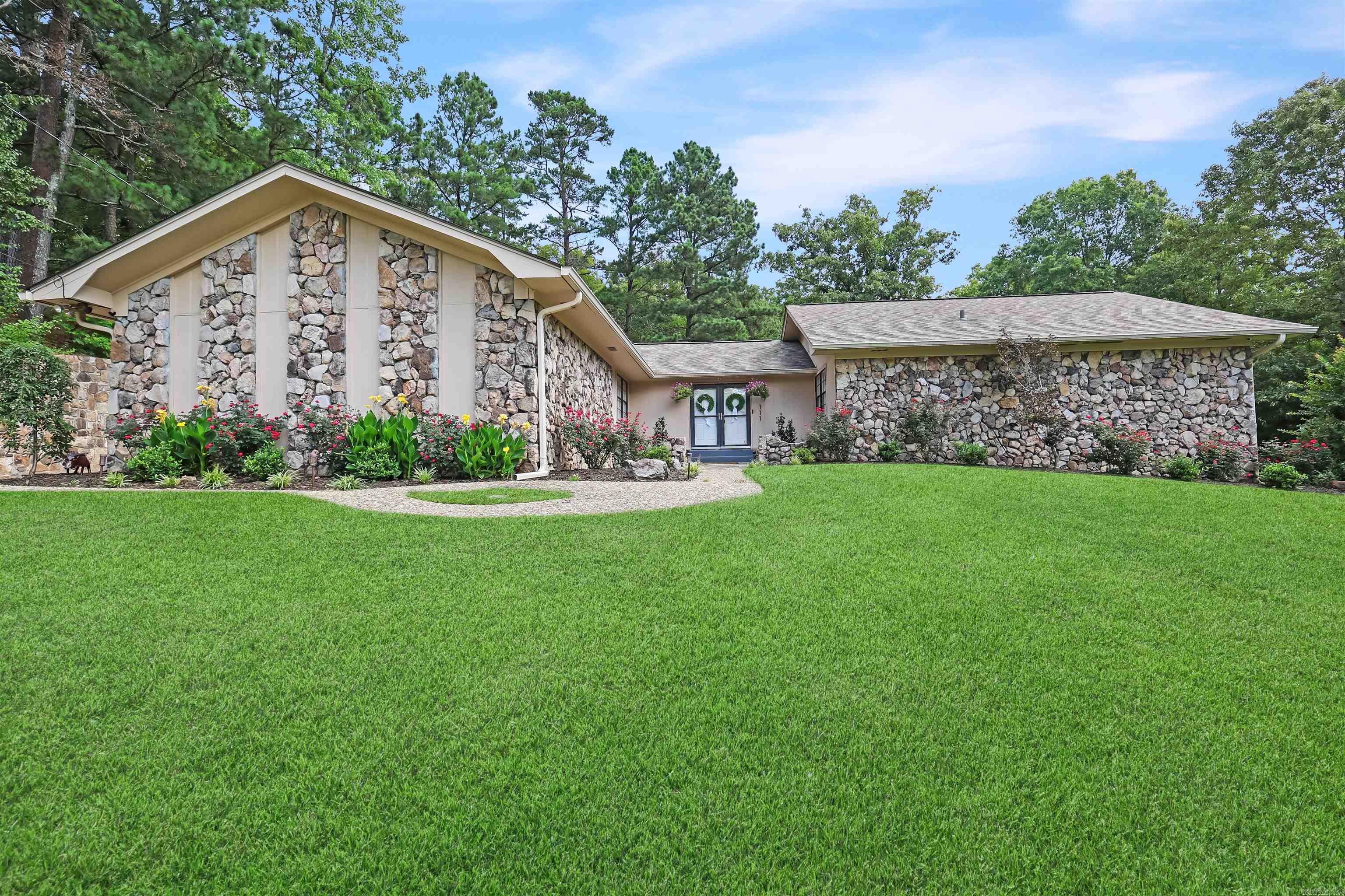 This charming yet modern 3 BR, 2 bath home is tucked at the end of a cul-de-sac and sits peacefully on a generous 0.65 acre lot. Double front doors swing open to a sunken den that anchors the home crowned with exposed wood beams and a rock fireplace. The thoughtfully updated kitchen features new cabinets, quartz countertops, tile backsplash, a center island, breakfast bar, and a charming coffee nook for those early mornings. A formal dining room awaits gatherings worth dressing up for. The spacious primary bedroom delivers a true escape with an en suite bath dressed in stylish barn-style doors. Addt'l recent updates throughout include fresh paint, new flooring, updated fixtures, and scraped popcorn ceilings that quietly modernize every room. Sliders off the living room, dining room, and primary bedroom blur the line between indoors and out, leading to a fenced backyard built for entertaining. A 2-car garage adds practicality while the location seals the deal, near the Country Club and everything Hot Springs has to offer, and within the highly desired LSSD. Refreshingly private, and brimming with personality, this is the kind of home that simply feels right the moment you arrive.