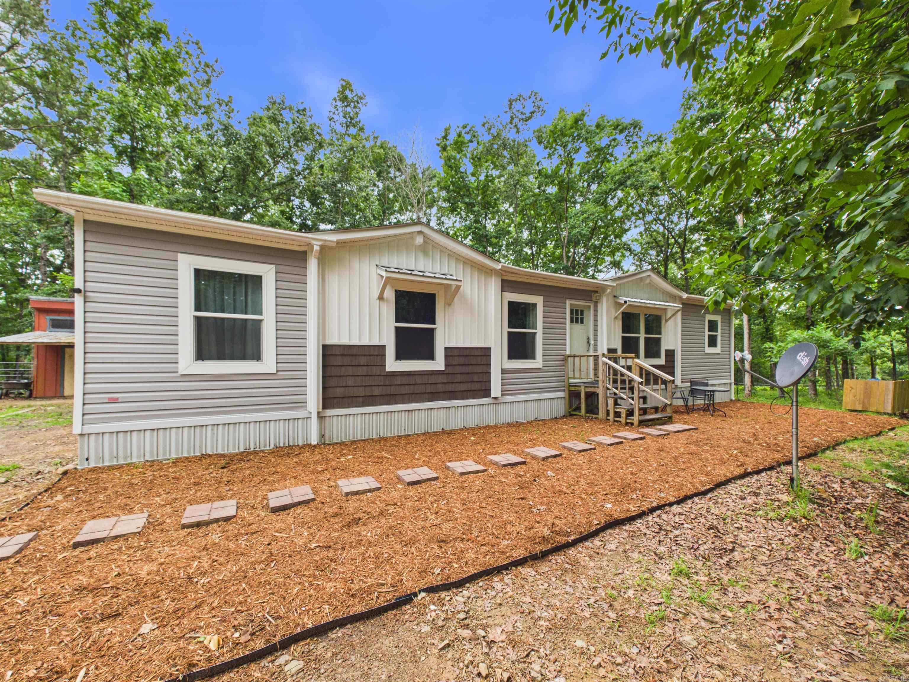 Country Living with Freedom & Convenience on 2.5 +/- Unrestricted Acres!    Looking for space, flexibility, and a great location? This 2021 manufactured home on a permanent foundation offers 1,568 sq. ft +/-, with a spacious open-concept layout featuring 3 bedrooms and 2 bathrooms, all situated on 2.5 +/- gorgeous unrestricted acres with endless possibilities.   The home features:   Large kitchen with island • Pantry for added storage • Spacious dining and living areas • Split-bedroom floor plan with the primary suite separated from the guest   bedrooms for added privacy • Back deck perfect for enjoying beautiful sunset views Bring your livestock, build a shop, add additional structures, or create the property you've always wanted — with no restrictions holding you back!    Conveniently located: • Only 5 miles to South Fork Recreation Area and Greers Ferry Lake boat launch • Just 6 miles to downtown Clinton • Approximately 7 miles to the hospital • Enjoy peaceful country living while remaining close to town amenities   Whether you're looking for a primary residence, hobby farm potential, or simply room to spread out, this property allows you to make it your own.