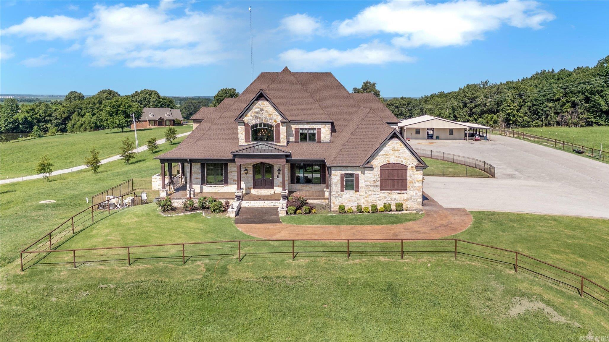 Welcome to Cypress Ranch, located at 136 County Road 107 in Jonesboro. This is an extraordinary gated luxury ranch estate offering 62.33 acres of privacy, natural beauty, and exceptional craftsmanship just minutes from Jonesboro, Arkansas. This remarkable property features a custom built 7,350 square foot residence with 4 bedrooms and 4.5 bathrooms, thoughtfully designed for comfort, security, and refined ranch living. Inside the home, you will find extensive cedar woodwork, spacious living areas, and a gas and wood burning fireplace that creates a warm and inviting atmosphere. The fully finished basement provides additional living and entertainment space, while two large reinforced safe rooms offer peace of mind and security. The home is also equipped with a full home generator, smart home security system, and a new roof installed in 2025, ensuring reliability and modern convenience. Step outside to experience resort style amenities, including a heated and cooled saltwater pool, hot tub, and beautifully maintained grounds overlooking a fully stocked front pond. The outdoor spaces are ideal for relaxing, entertaining, or simply enjoying the quiet surroundings and scenic views.