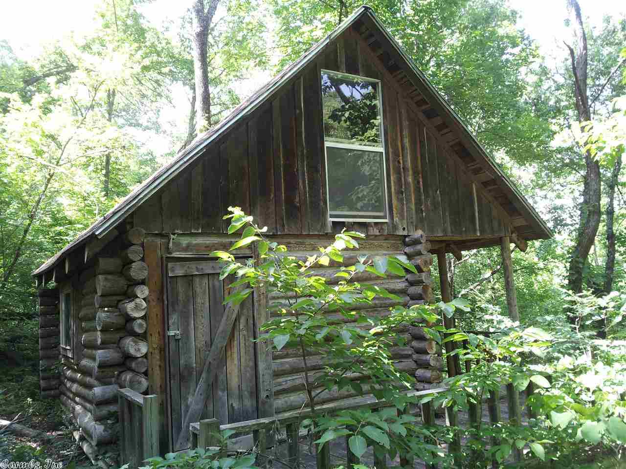 Remote Log Cabin built on 20 acres of timber overlooking a creek near Marshall in Searcy County Arkansas. Gated access to a dim road winding through the forest and ending at this Cabin. Cabin has water and even a small fire hydrant. Many features to enjoy on this tract...Turkey, deer and bear hunting (zone 1) as well as other small game. Cabin features a deck and a covered back porch, a wood buring stove to cook and heat with and a loft for a couple of beds. Truly a wilderness get away with only the sounds.