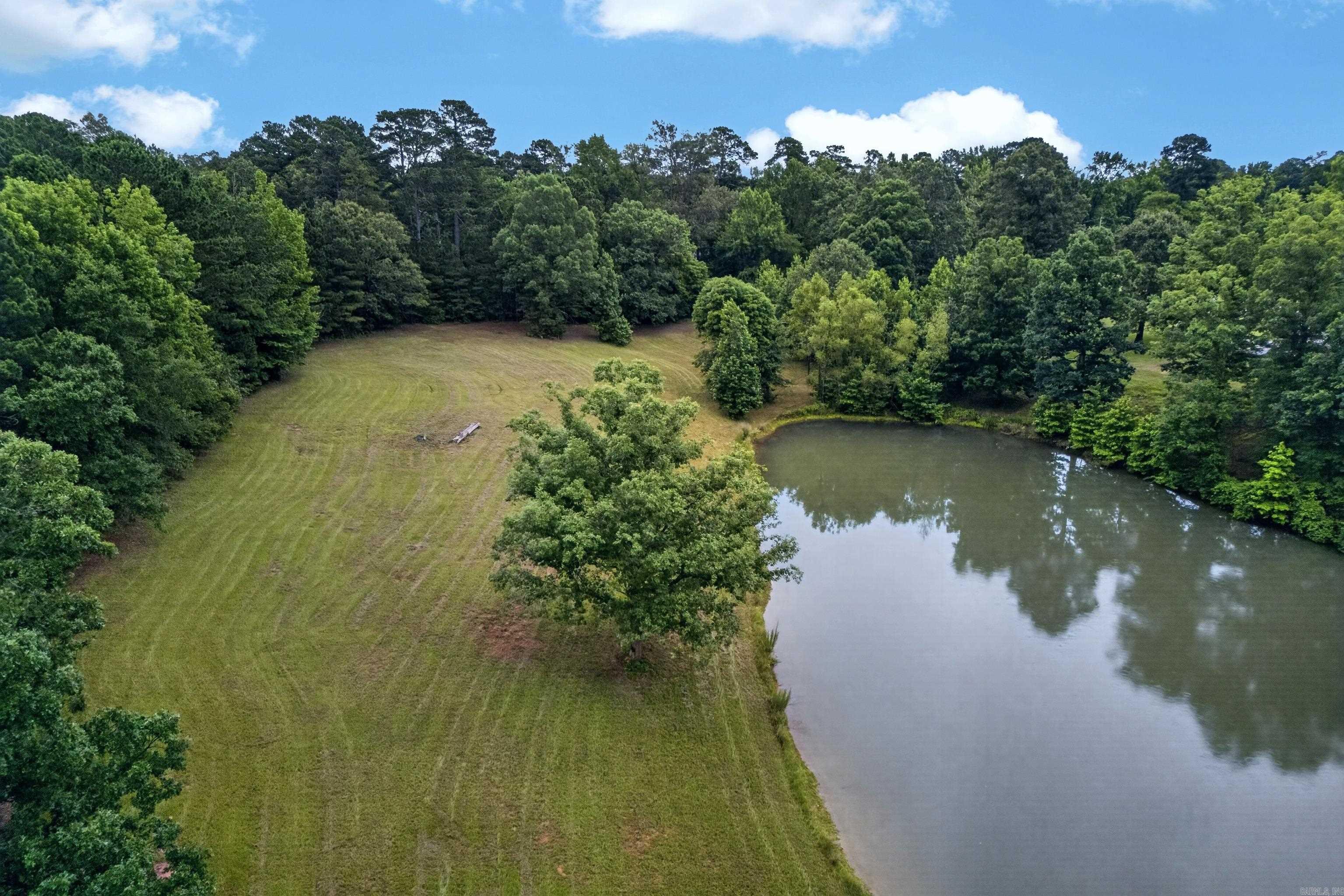 Escape to your own private retreat on this beautiful 6.03-acre property featuring a scenic pond, open pasture, mature trees, and a large utility building. The property offers a perfect blend of cleared land and wooded privacy, creating an ideal setting for a future homesite, recreational getaway, or hobby farm. A 36' x 50' utility building provides ample space for equipment, vehicles, storage, or workshop use, while the attached 12' x 48' lean-to adds additional covered storage. The picturesque pond serves as the centerpiece of the property, offering opportunities for fishing, wildlife viewing, and peaceful outdoor enjoyment. Surrounded by nature yet conveniently accessible, this unique tract provides endless possibilities for those seeking space, privacy, and the beauty of country living.