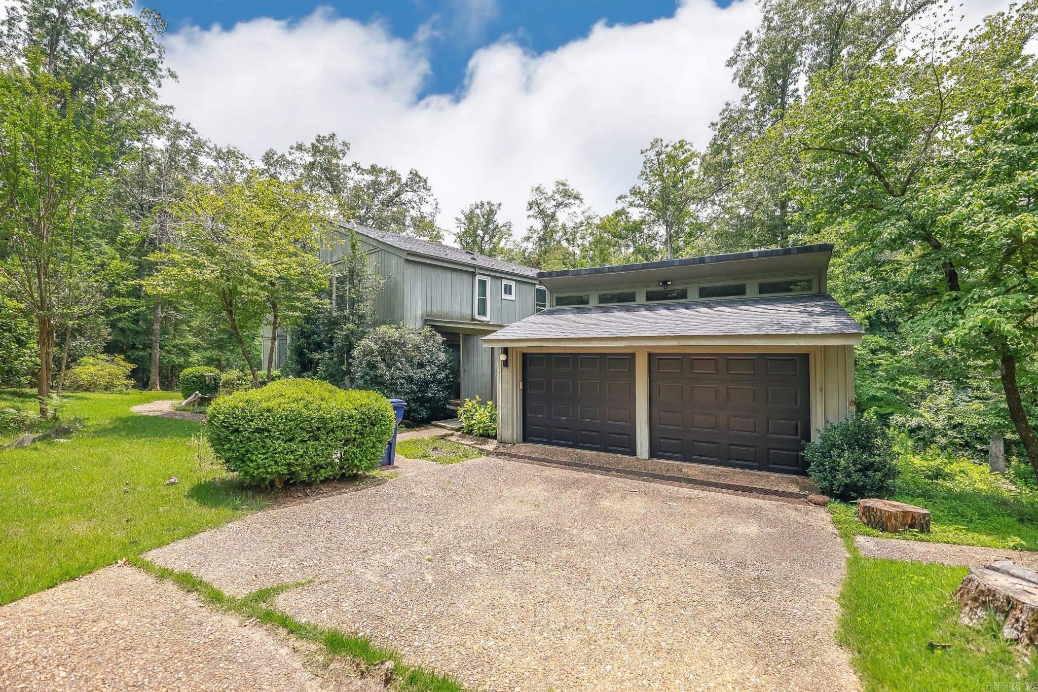 Looking for space, style, and privacy?  This generous midcentury home sits on near 5 peaceful, wooded acres with beautiful landscaping and versatile floor plan.  With 4 bedrooms, a walk-out basement with extra den, and several bonus areas, there's opportunity to curate the space to your needs.  Inside, you'll find classic contemporary charm -- dreamy windows, clean lines, two-story vaulted living room, and an atrium that brings in natural light and serene views.  It's the kind of home that feels connected to nature, while still offering comfort and function.  The thoughtfully developed landscaping is balanced with views of mature trees, shady paths, and access to the back patio with easy access to the detached garage and storage building. The sellers installed a new roof and HVAC system in 2024, leaf filter gutters, and will transfer a lifetime window warranty at closing. This unique home gives you that perfect blend of serenity, style, and space in a sought-after location that feels like you're miles from the busy-ness of town with quick access to local amenities. Fridge, washer & dryer to convey with acceptable offer.