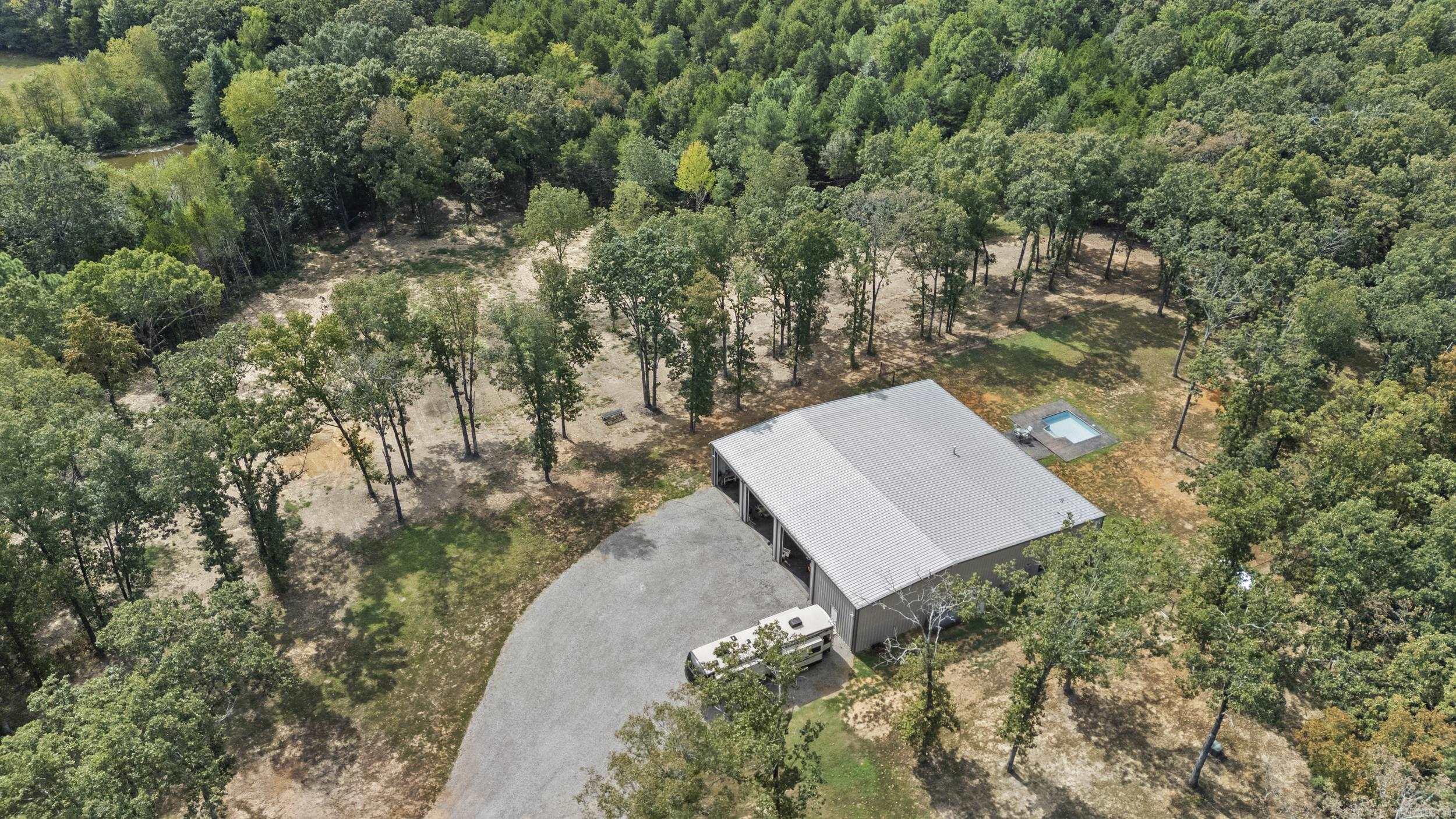 Work here, play here, live here! This one-of-a-kind barndominium sits on 12.77 acres just minutes from the city limits of Searcy offering approximately 1920 sq ft of H/C living space, 4800 sq ft of insulated H/C shop space.This red-iron building perfectly blends, comfort and function. Inside its all about the details-crown molding, custom cabinetry, wall ovens built-in grill,  spa-style shower. Outdoors, you'll find an in-ground pool, fenced yard and an 8 x 12 storage building with electric. Perfect for downsizing or retirement living, with space to expand if desired. Private and peaceful setting close to everything.