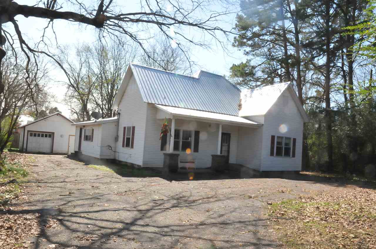 Wonderfully secluded house tucked away in the middle of town!  Beautiful hardwood floors. Separate Laundry.  Formal living room, separate dining room. 2 out buildngs. Lots of parking!