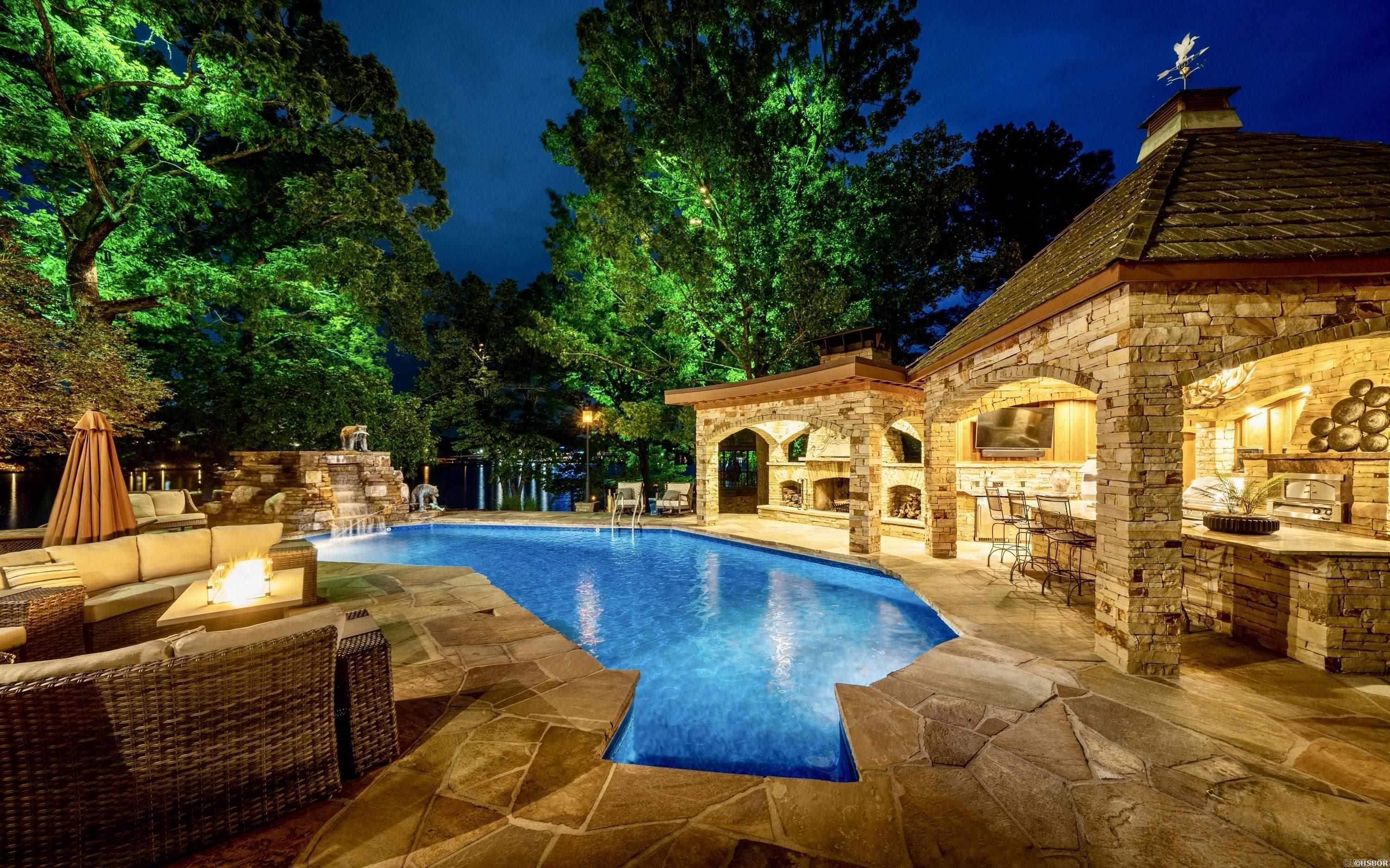 Welcome to one of Lake Hamilton's premier waterfront estates, where timeless architecture, exceptional craftsmanship and resort-style amenities create an extraordinary living experience. Privately gated & surrounded by lush landscaping, this 4-BR, 4.5-BA custom home offers both elegance and privacy in the heart of town. Rich wood accents, soaring ceilings and striking stone fireplaces with handcrafted redwood mantels define the home's warm, sophisticated interior. The gourmet kitchen is designed for both everyday living and effortless entertaining. The main-level owner's suite is a true retreat, complete with a sitting area, private fitness room and a spa-inspired bath featuring a copper soaking tub and steam shower. Designed for year-round enjoyment, the outdoor living spaces include a resort-style pool, Michael Phelps swim spa, waterfalls, fountains and a covered outdoor kitchen with a stone fireplace. A new wooden boardwalk spans the shoreline, leading to a covered two-stall dock with two boat lifts and a PWC lift, all framed by breathtaking Lake Hamilton views. Offered fully furnished, this estate is a rare opportunity to own one of Lake Hamilton's finest luxury properties.