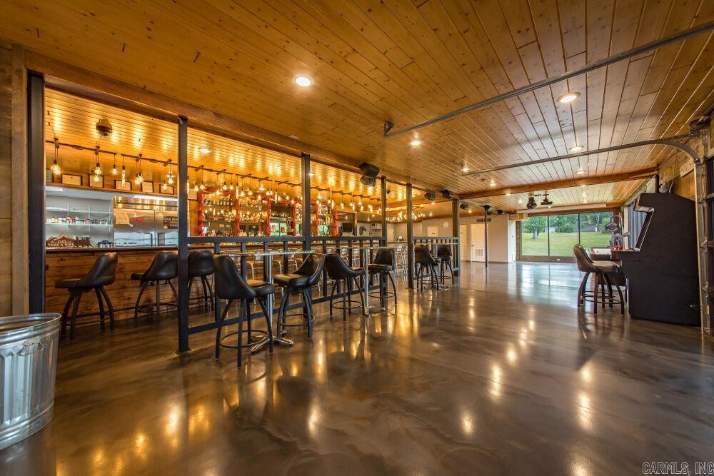 Suite 203: The Greers Ferry Yacht Club - A lakeside landmark offered at auction and ready for its next chapter. Formerly home to the renowned Greers Ferry Yacht Club bar and grill, this second-floor commercial space offers a rare opportunity to continue its legacy as a restaurant, bar, or event venue, or transform it into a one-of-a-kind waterfront residence. Features include an expansive open floor plan with stained concrete floors, a built-in U/L-shaped bar, integrated speaker system, projector, multiple flat-screen TVs, existing kitchen/service area with stainless sink and walk-in freezer, and multiple half baths designed for high-traffic use. Large windows and a spacious deck provide sweeping views of Narrows Marina and Greers Ferry Lake. Additional amenities include central HVAC, fire alarm system, security cameras, multiple emergency exits, commercial glass entry doors, and a firehouse-style roll-up garage door. Offered through the Buyer’s Ultimate Choice auction with SOLDasap LLC. Buyers may bid on this property individually or as part of a larger offering. Please visit soldasap.com or call 870-236-6117 for terms and conditions.