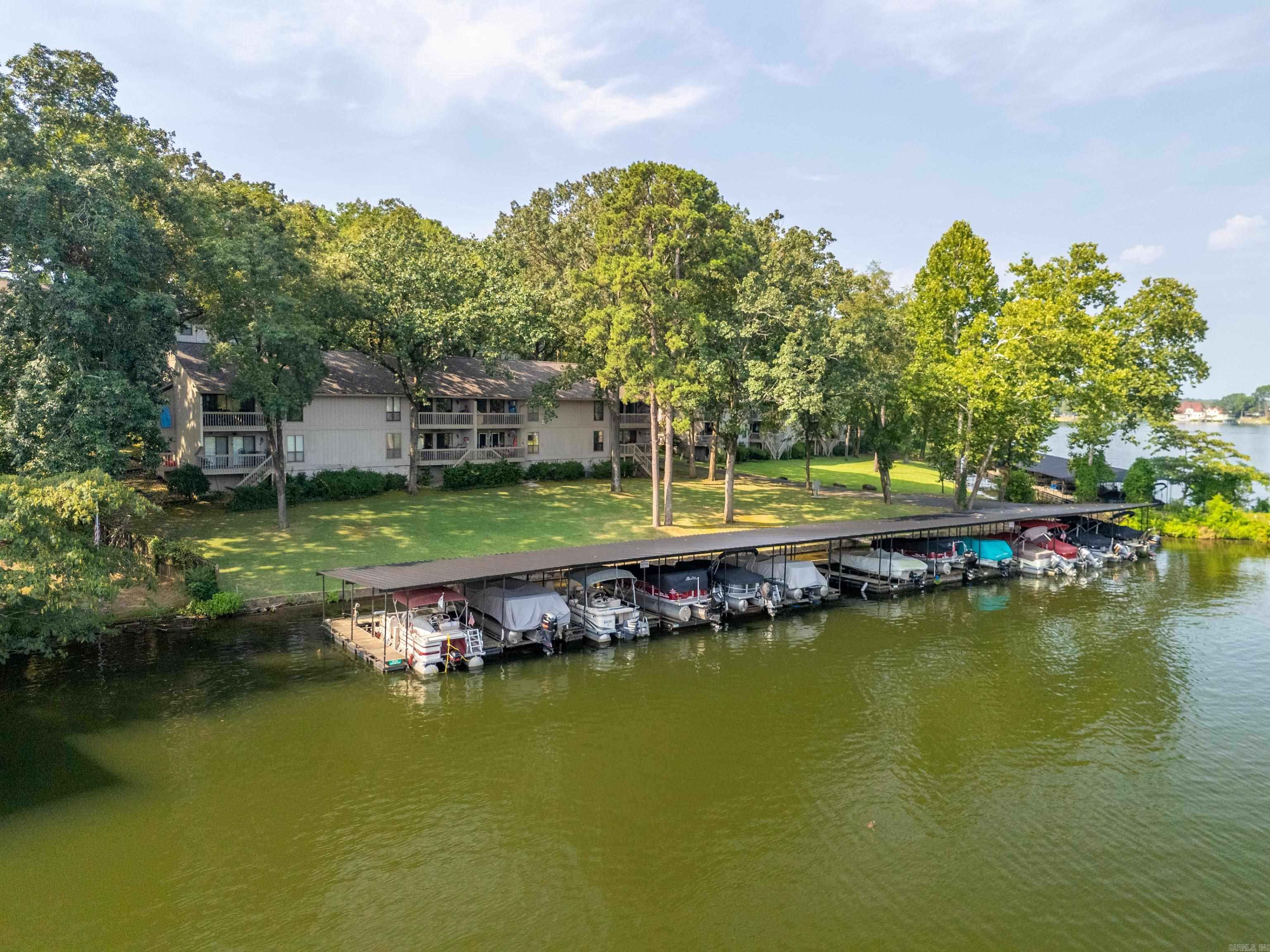 Lake Hamilton Condo with view and access. Start your mornings with the serene beauty of lake vistas from your deck, the perfect place for savoring a morning coffee or unwinding in the evening. This condo features two spacious decks, and granite counter tops throughout. The primary suite features built in dresser/vanity for additional storage. Community offers a range of amenities, including a pool and an assigned boat slip with a lift that will convey. Assigned parking and guest parking available. Washer, dryer, and microwave to convey. No Short term rentals allowed.