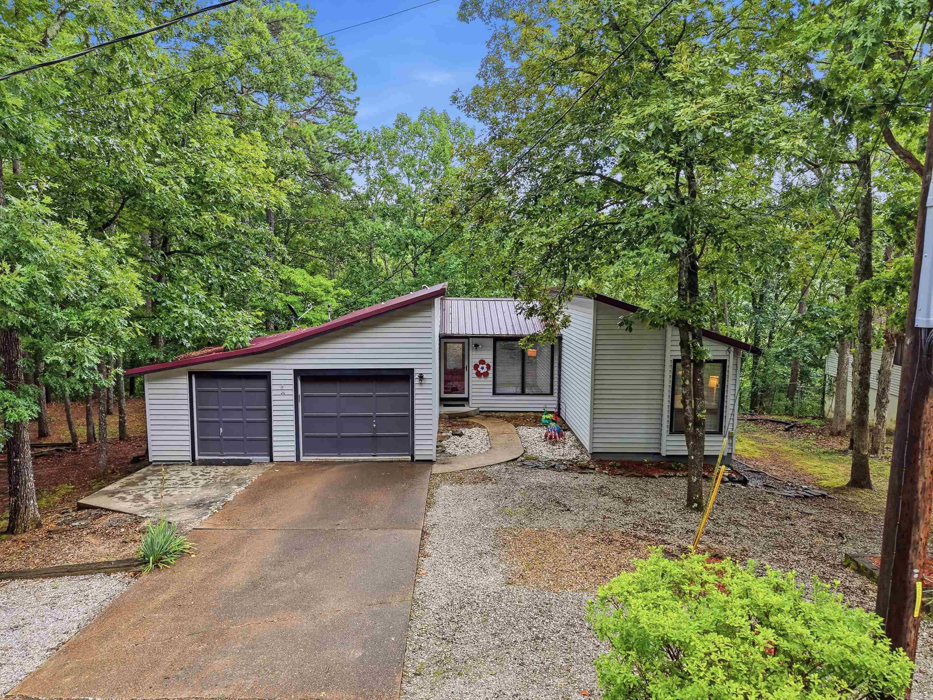 Enjoy easy living in this nicely updated Fairfield Bay home featuring a durable metal roof, low-maintenance yard and a partially fenced area. The inviting kitchen offers granite countertops and new stainless-steel appliances, while the spacious laundry room provides additional pantry storage. Relax in the comfortable sunroom overlooking the peaceful, wooded backyard—an ideal place to enjoy your morning coffee, read a book or watch the wildlife. After a rainfall, a seasonal wet-weather creek adds to the natural beauty of the property. Workshop areas in both the garage and crawlspace offer plenty of room for projects, tools and storage. The home is being sold partially furnished, making your move even easier. Conveniently located near Fairfield Bay’s golf courses, swimming pools, pickleball courts, ATV/UTV trails, hiking and other community amenities—and approximately 15 minutes from beautiful Greers Ferry Lake. Whether you are looking for a full-time residence or a relaxing weekend getaway, this home is ready to enjoy!