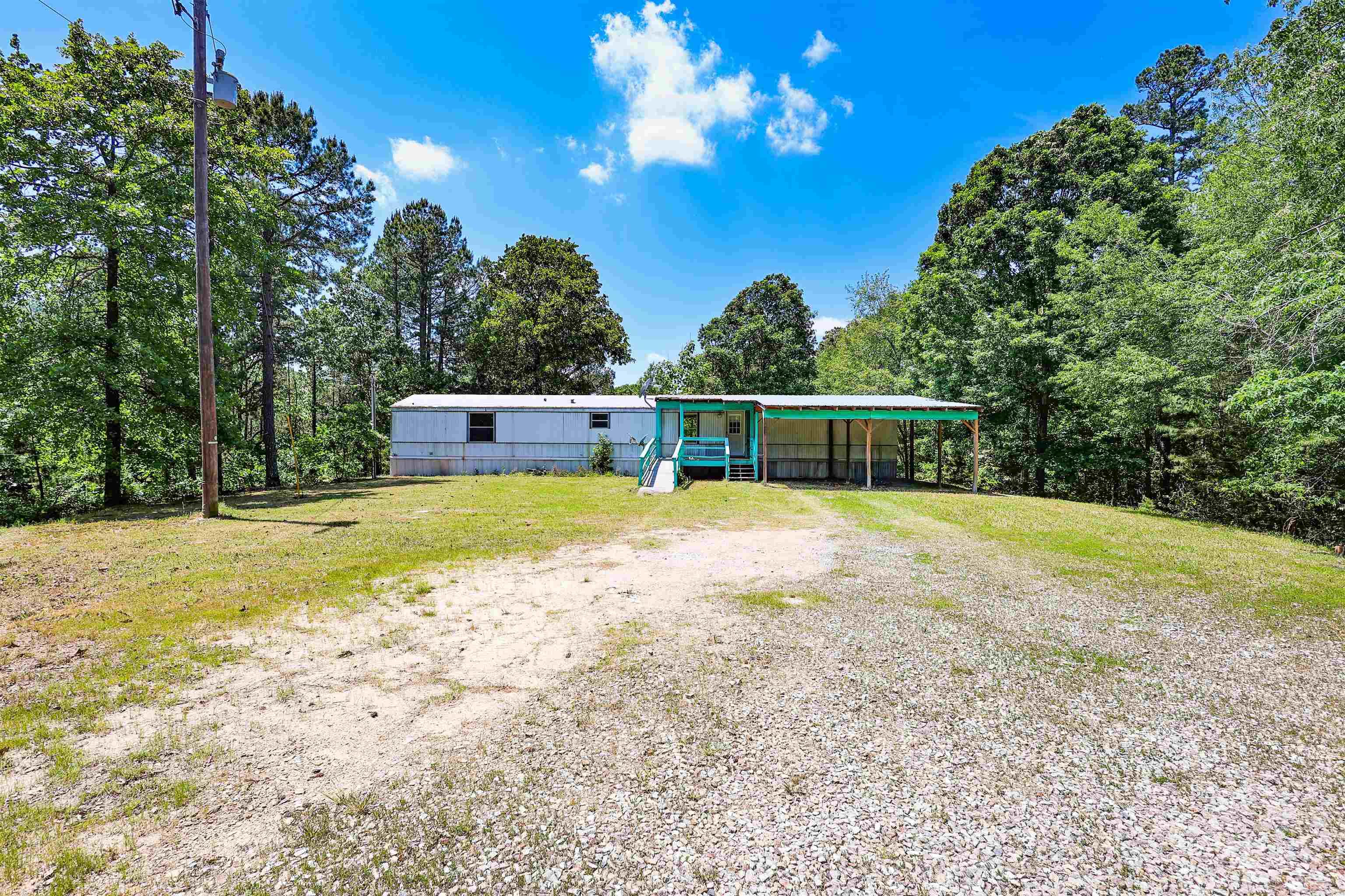 Nestled on 4.27 wooded acres in the sought-after Fountain Lake School District, this 3-bedroom, 2-bath single-wide mobile home offers privacy and potential. The quiet, convenient location makes it ideal for those looking to enjoy a peaceful setting without being far from town. Property features well water and includes a cute playhouse or storage shed. Whether you’re searching for an investment, rental, or a place to make your own, this property is full of opportunity.