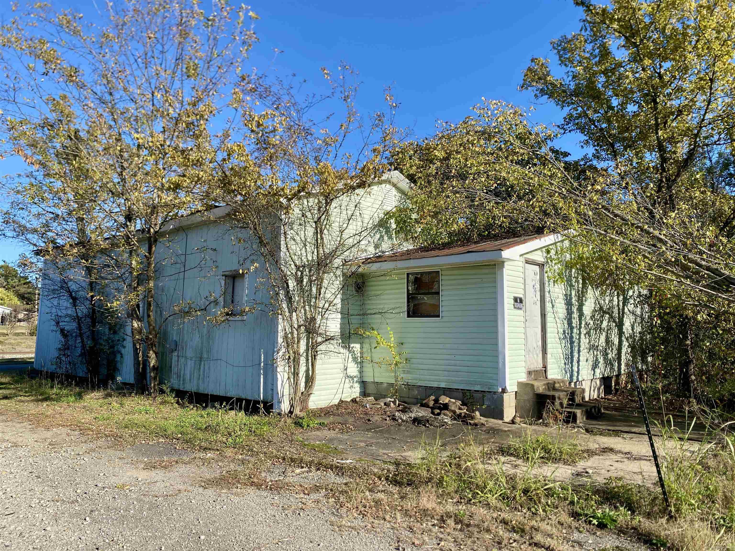 Approx. 1,800 sq.ft. of space featuring 7 rooms with ample layout potential for a 4 bedroom, 2 bath home. Solid wood structure with original wood walls, ceilings, and floors throughout. The home has remained mostly protected from the elements, offering a great opportunity for a handyman, investor, or remodeler to restore the property to its original charm and character. Situated on a paved corner lot measuring approximately 100x150 with all utilities on site including sewer. Excellent potential for renovation, rental income, or a custom home project.