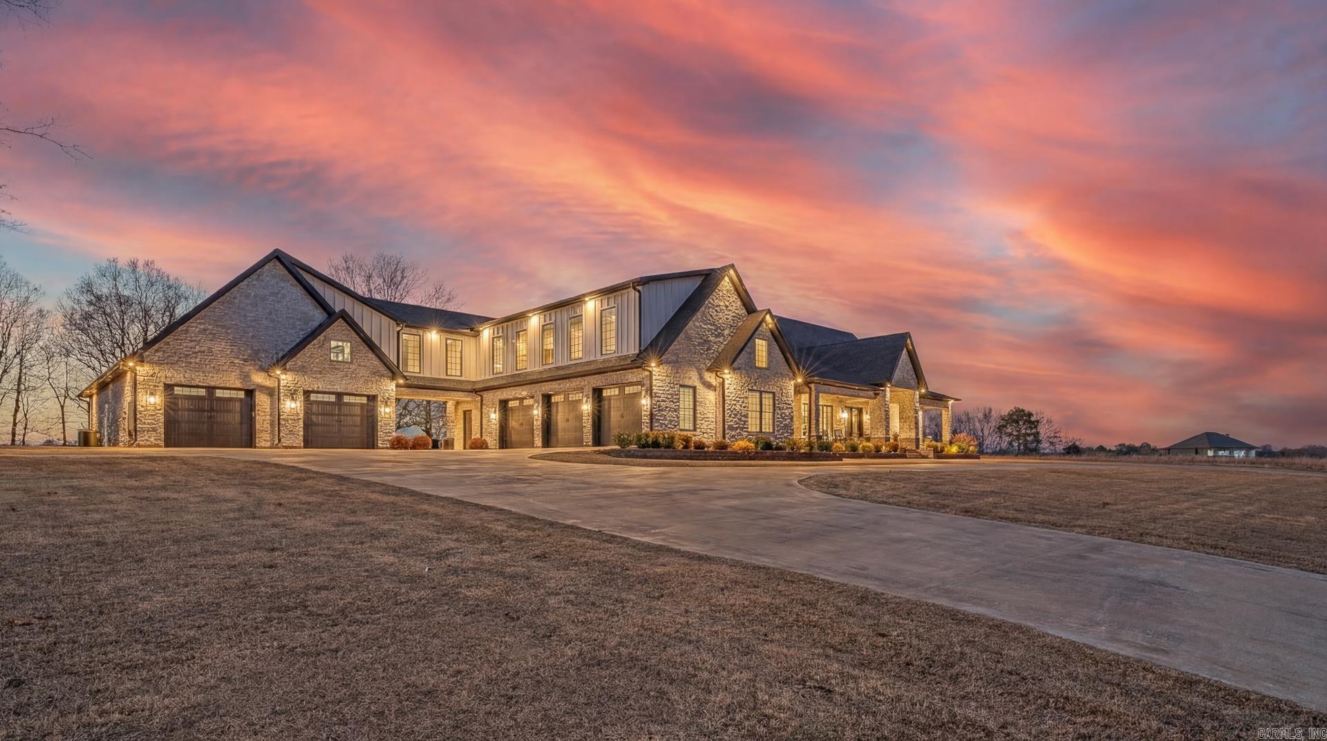 Custom-built luxury estate on 3 private acres engineered as a true forever home. Flexible 4–6 bedroom, 7 bath layout, two great rooms with fireplaces, two studies, game room, craft room, and oversized safe room with bath. Chef’s kitchen features 4-foot commercial gas range, custom cabinetry, quartz countertops, farmhouse sinks, walk-in and butler’s pantry. Commercial wood plank flooring, brick accents, custom trim, soaring ceilings. Guest quarters includes full kitchen & laundry. Superior construction includes 2x6 foam-insulated walls, reinforced slab with steel tie-downs, Marvin fiberglass windows, dual fuel Lennox HVAC, four tankless water heaters, foam-insulated attic with extensive heated/cooled storage, and generator backup with 1,000-gallon underground propane tank. Outdoor living offers screened patio with fireplace & outdoor kitchen, fire pit, full basketball court, circle drive, and five-car insulated garage with 220V in each bay. Positioned on a dead-end street, the property enjoys peaceful pond views that enhance the sense of privacy and natural beauty