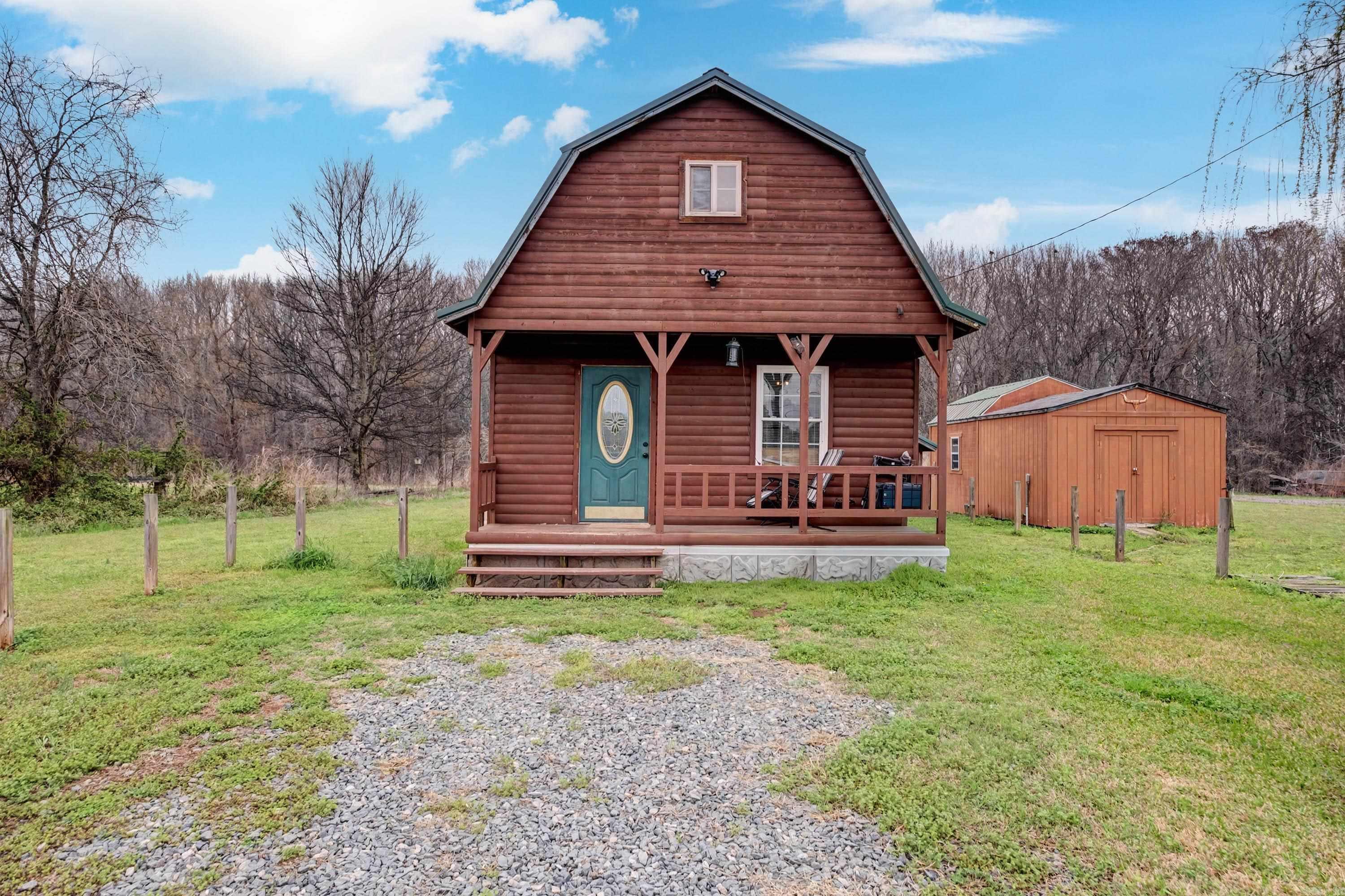 Charming 1 bedroom, 1.5 bathroom log cabin nestled on a large lot in a quiet and peaceful setting. This adorable cabin offers rustic charm with a cozy feel, making it perfect as a full-time residence, weekend getaway, or investment opportunity. The spacious upstairs bedroom provides plenty of room and could easily be configured to create a second bedroom or additional living space if desired. Enjoy the privacy and tranquility of the surrounding area while still having room to expand or entertain outdoors.