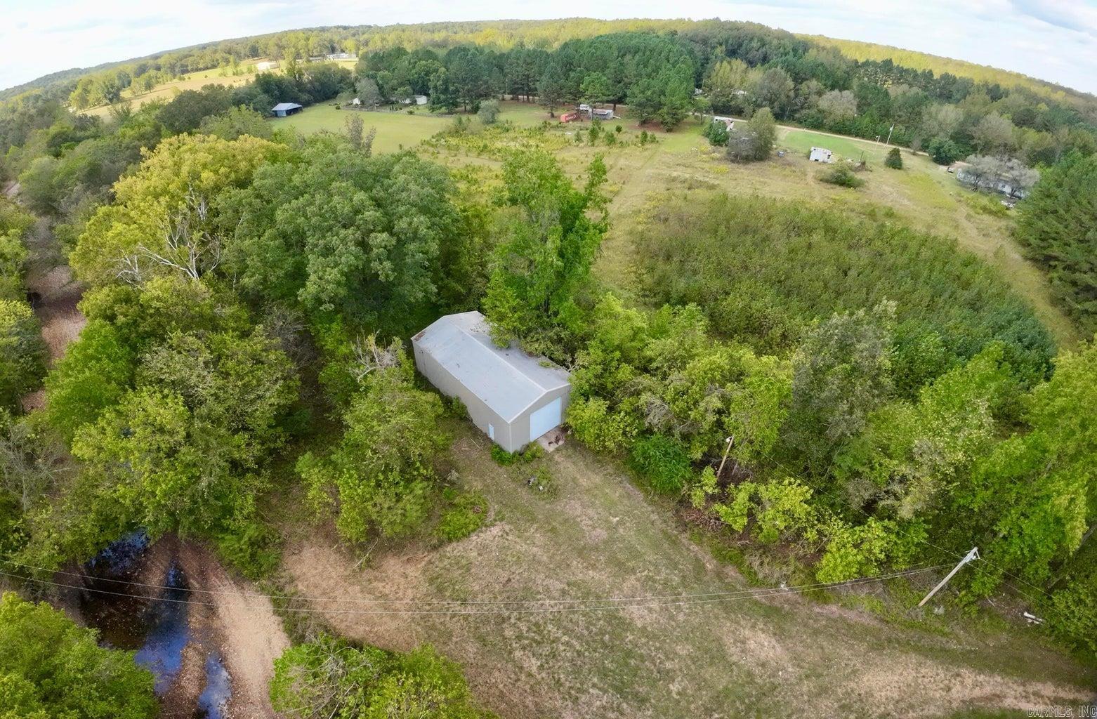 OWNER FINANCING! Need Storage? Fabrication/Mechanic Shop? Unique opportunity with land and a large metal building. The peaceful private setting for this 2.89 Acres with approximately 800ft of creek frontage is ideal. The property boasts a large 1800 sq ft 30'x60' metal building with concrete floors, electric service, and 14 foot doors on each end. This building offer tons of potential for uses for storage, your personal mechanic shop, farm equipment storage, or even as a shell for a barndominium. Previously used as a Diesel Mechanic Shop you know it's big if you could drive a big rig through it. Water is available at the county road. Agent owned.
