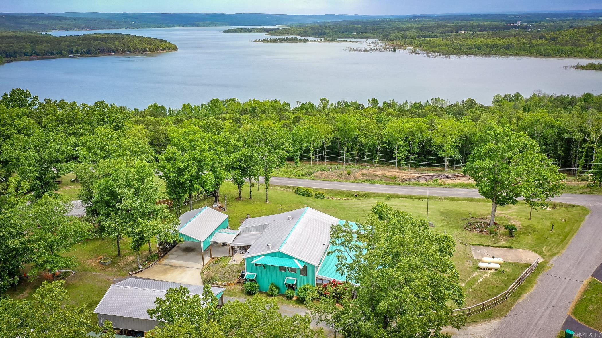 Stunning Panoramic views of Greers Ferry Lake overlooking Higden Bay! A total of 8 lots including approximately 4 acres!!(4 lots with the home & 4 lots across the street to maintain your amazing lake & vista views! This property is so unique & one of kind, you won’t find another one like it.The sellers have lived here full time since home was built & includes whole house backup Generac Generator (done by Mr. Sparky & on its own propane tank that will stay), Clean Storm Shelter, a huge sleeping porch with a 1/2 bath & setup w/kitchenette space including sink, refrigerator, TV, washer/dryer, bed,  & Bistro Table (such a cool space, you must see.Wood burning stove can be negotiable for separate price).The Cabin will come with most of the furniture items (sellers have some furniture pieces that won’t stay  like the bedroom furniture in the downstairs bedroom that was seller’s moms & some other select items). All kitchen appliances in the home will stay including the gas space heaters (not deep freeze). Home has central heating & air,24x30 attached carport , 30x50 detached garage, RV hookups, Primary Bedroom has walk out screened porch off sliding glass door, & oversized walk in shower.