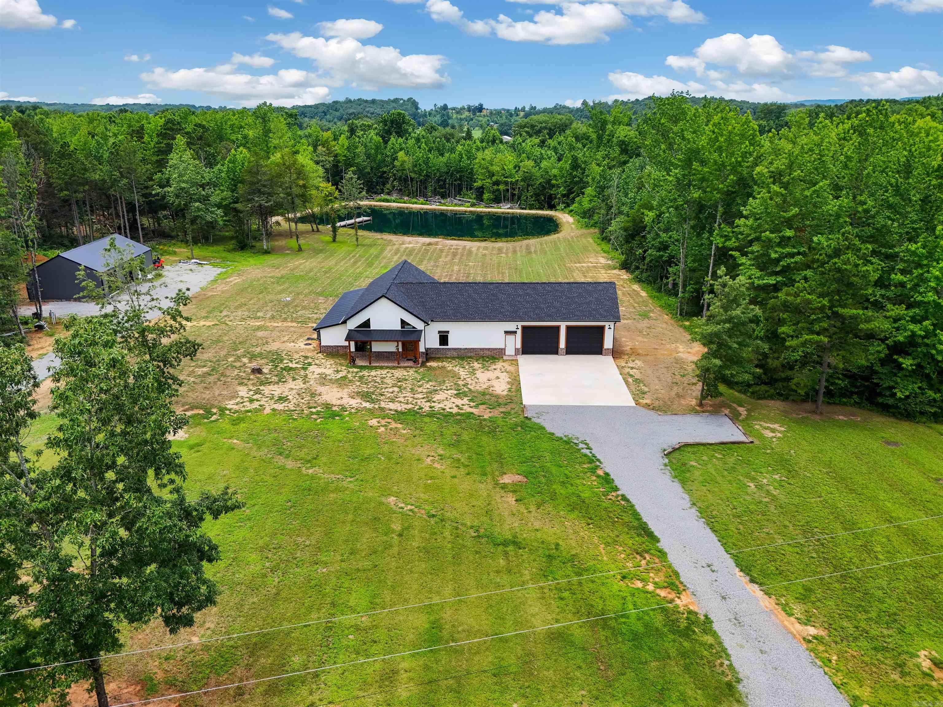 Behind a private gated entrance on 2.93 acres, this stunning new construction, 3-bedroom, 2.5-bath home offers 3,403 square feet of thoughtfully designed living space. The open living area features a soaring tongue and groove wood ceiling, a gas fireplace, luxury vinyl and concrete flooring throughout, and a spacious kitchen with granite countertops and a large pantry.  The primary suite includes a relaxing sitting area or office space, and you'll also find a dedicated office plus a bar/game room perfect for entertaining. Outside, enjoy the expansive 1,060-square-foot back deck, a 1,200-square-foot attached garage, and an impressive 30' x 56' shop. Privacy, space, and quality finishes make this property a rare find! Be sure to check out the 3D tour and aerial drone photos.