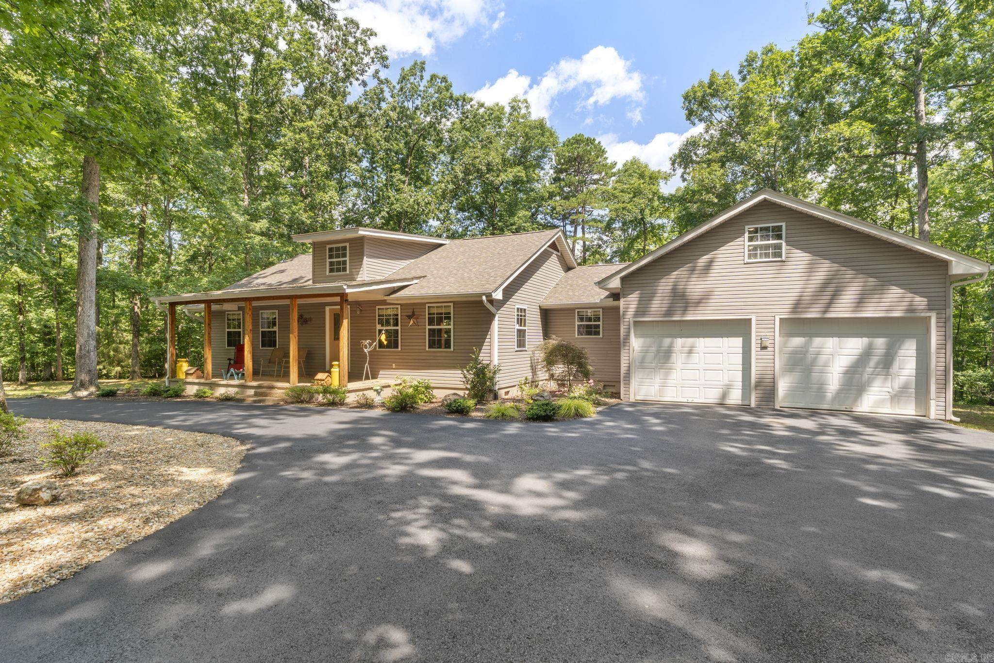 Serene Country Elegance in a Woodland Setting Situated on over 2 acres of wooded privacy, this custom estate offers a blend of rustic charm & modern luxury. This property boasts extensive recent upgrades that provide absolute peace of mind, including granite countertops, luxury floor tile in the kitchen, the baths and the entrance, and new engineered flooring in the great room and bedrooms, new roof covering, and a new water heater.  The great room is defined by its vaulted cathedral ceilings w/ intricate custom wood accents and a Siltstone wood-burning fireplace, and flows effortlessly into the kitchen, which has been  modernized with premium countertops. The residence has 2 bedrooms and 2.5 baths,  a primary suite with elegant finishes & walk-in shower. The bathrooms have been beautifully refreshed, and upstairs, a bonus room offers  versatility as an executive office, media room, bedroom or guest quarters, & convenient attic storage access. The outdoor spaces are equally impressive, w/ covered porches, a sustainable rain-barrel-fed garden, an asphalt circle drive w/ new landscaping. with a 2-car garage, & detached 18'x12' workshop. Convenient just off of 7 South. See remarks.