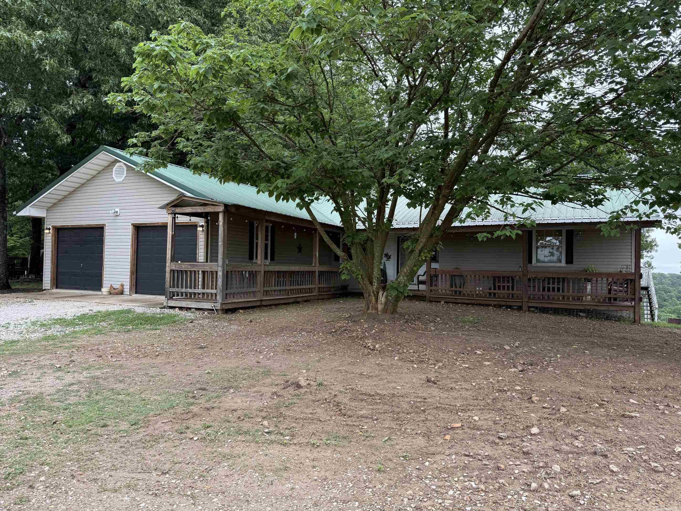 Nestled in the Ozark Mountains near the Buffalo National River area, this approx. 1.3 acre property offers space, and distant mountain views! This 4 bedroom, 3 full bath home features a functional layout with 2 bedrooms and 2 full baths on the main level, along with a spacious living room conveniently located just off the kitchen and dining area. Enjoy relaxing outdoors from the covered front porch or the covered back deck overlooking the scenic Ozark landscape. The walk-out basement offers additional living space with 2 bedrooms, a full bath, and a kitchenette—ideal for guests, multi-generational living, vacation use, or additional entertaining space. Located in the heart of outdoor recreation with nearby hiking trails, the Buffalo River, and Ozark adventure opportunities just a short drive away. Just 10 minutes from Western Grove, AR on Hwy 123.