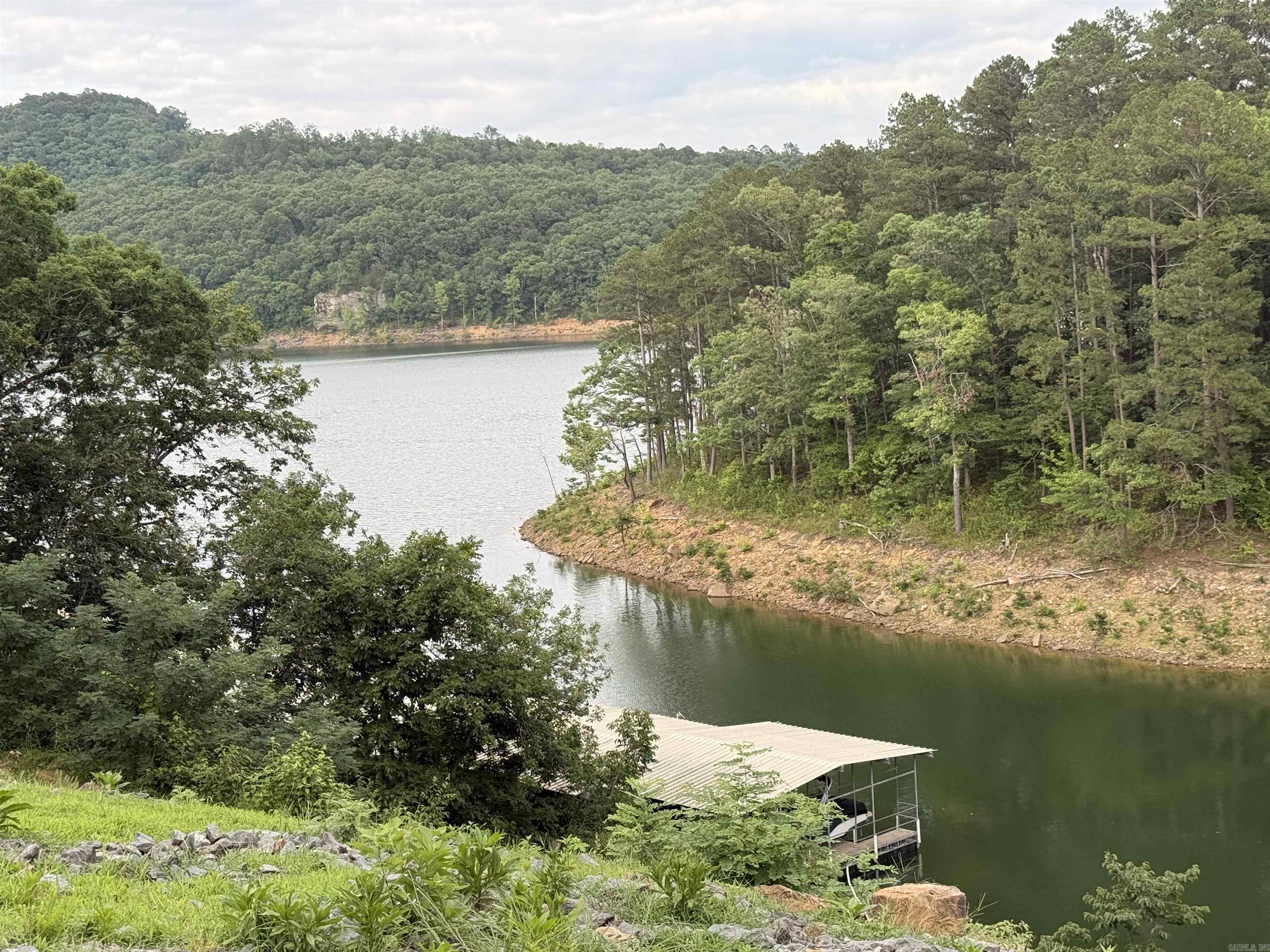 HELLO LAKEFRONT ACREAGE & BOAT SLIP!!!  7.15 acres Lake Front with great Lake & Vista Views which also INCLUDES easy accessible Boat Slip in the Watersedge Community Boat Dock. Parking lot designated for the community dock where you can park your vehicle/SXS/Golf Cart. Gravel Drive has been installed so you can drive down to the flatter spot & see the view from the lower side of the lot which would make awesome home site.  Two Septic Permits online under docs as well as the surveys. Water meter already set for city water.