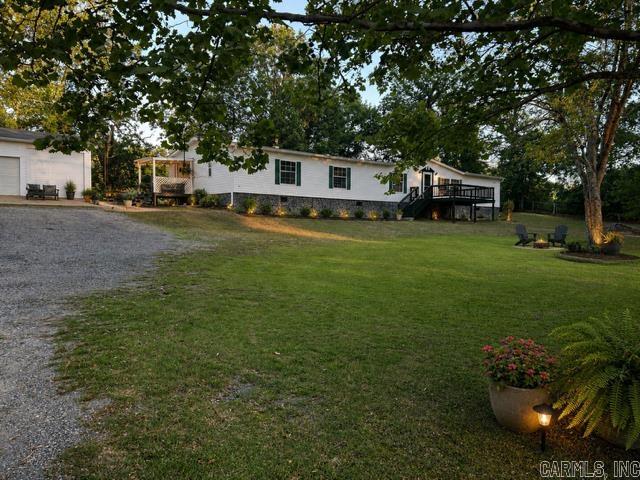 Spacious and beautifully updated 4-bedroom, 3-bath manufactured home offering 2,240 sq. ft. of living space on 1.2 acres with direct lake access! This versatile floorplan features a dedicated office, two separate living areas, and a separate dining space. One of the full bathrooms includes a convenient Jack-and-Jill layout. Recent updates include fresh paint throughout, upgraded luxury vinyl plank flooring, and completely carpet-free living for a clean, modern feel. Outside, you’ll find a huge fully fenced front yard, three separate decks — two covered — and an impressive 35x35 (1,220 sq. ft.) 3-car garage with attached shop complete with power, offering endless space for vehicles, storage, hobbies, or a workshop setup. The standout feature is the private lake access with a small dock, making it easy to launch a kayak, fish, or enjoy the water from your own backyard. Plus, enjoy the added bonus of a fully functioning well system with no wat  convey with acceptable offer. Hot tub is optional to convey with acceptable offer This property offers the perfect blend of space, updates, and peaceful lake living
